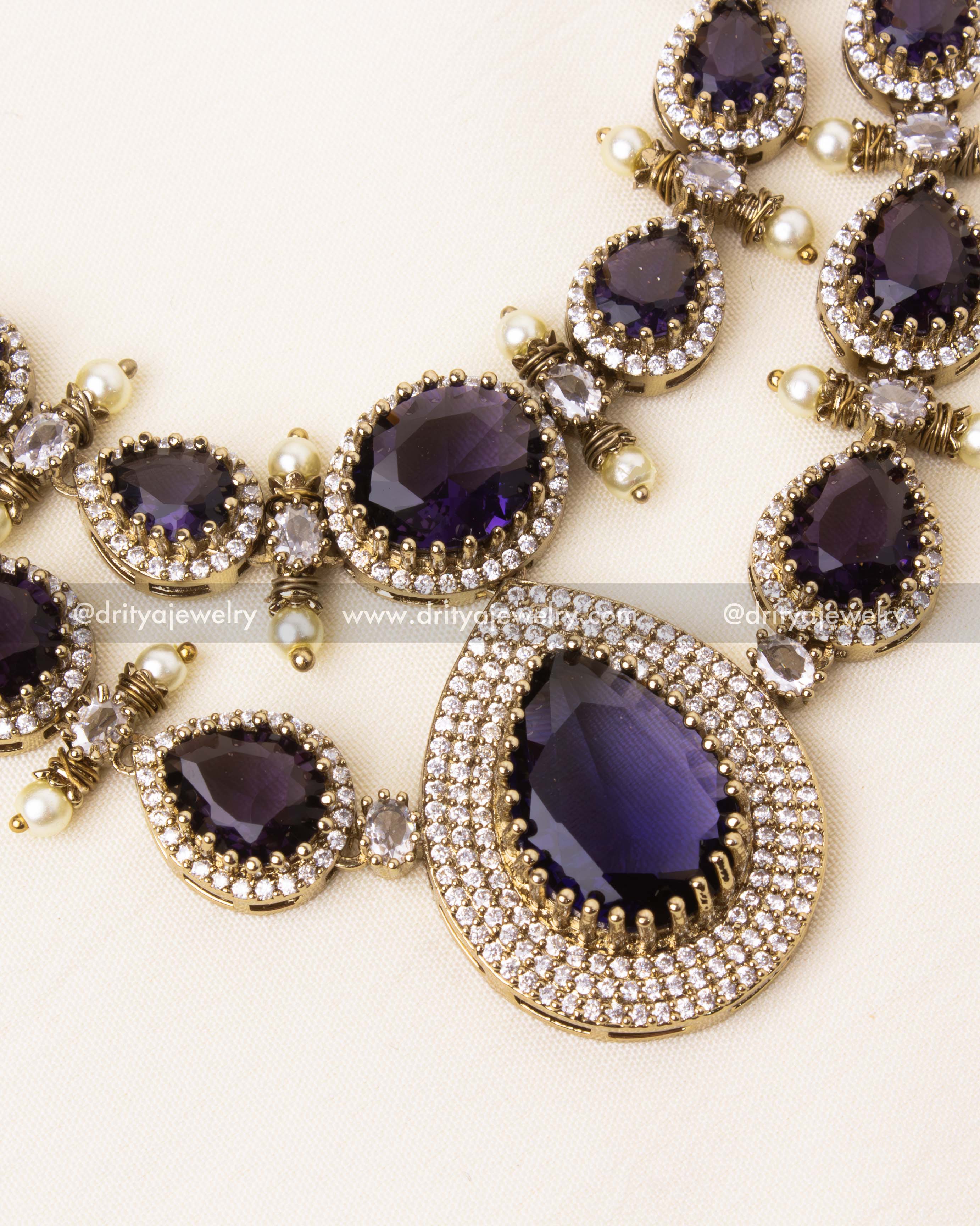 Detailed view of the teardrop centerpiece in the Victorian necklace, adorned with purple and AD stones.