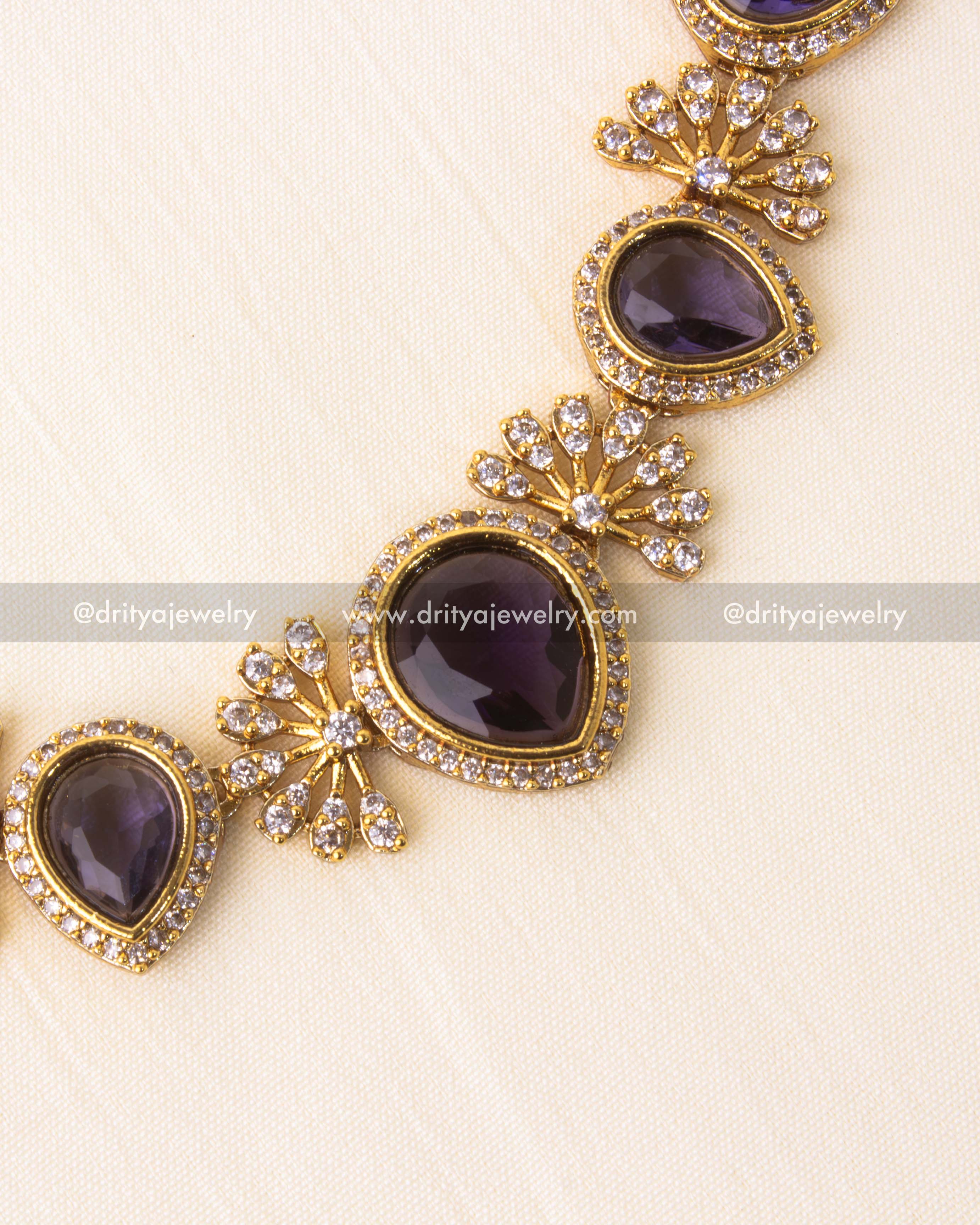 Detailed view of violet stone and floral diamond cluster in gold-plated short necklace.
