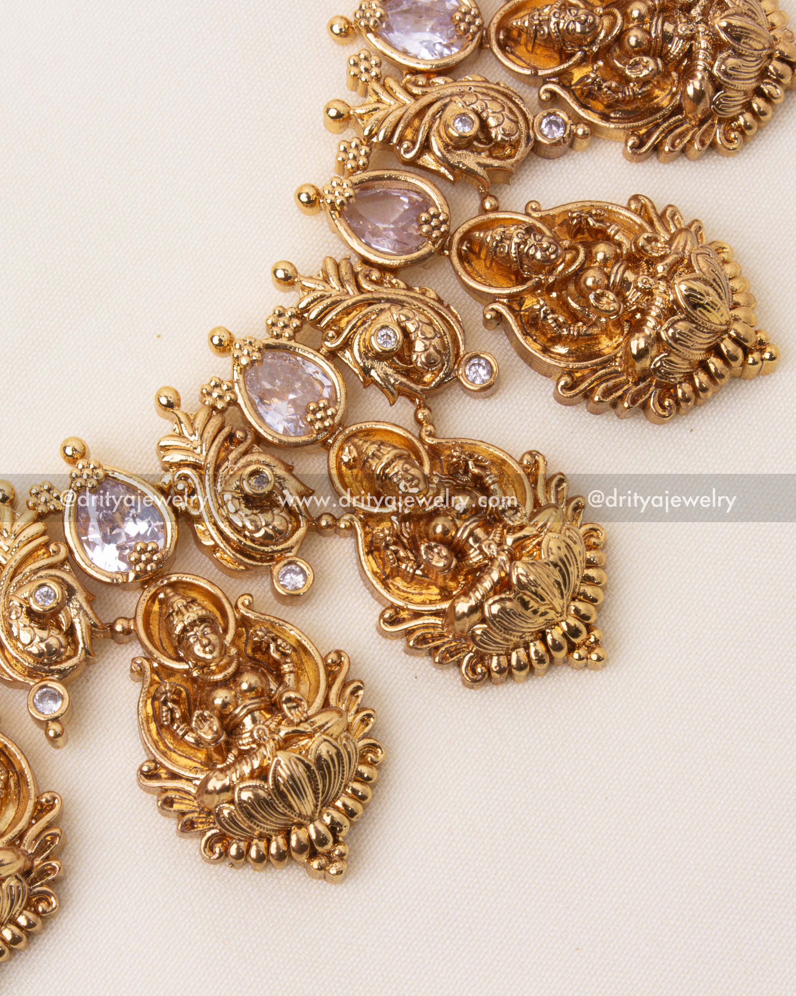 Intricate detailing of the long haram featuring Lakshmi motifs and shimmering white stones.