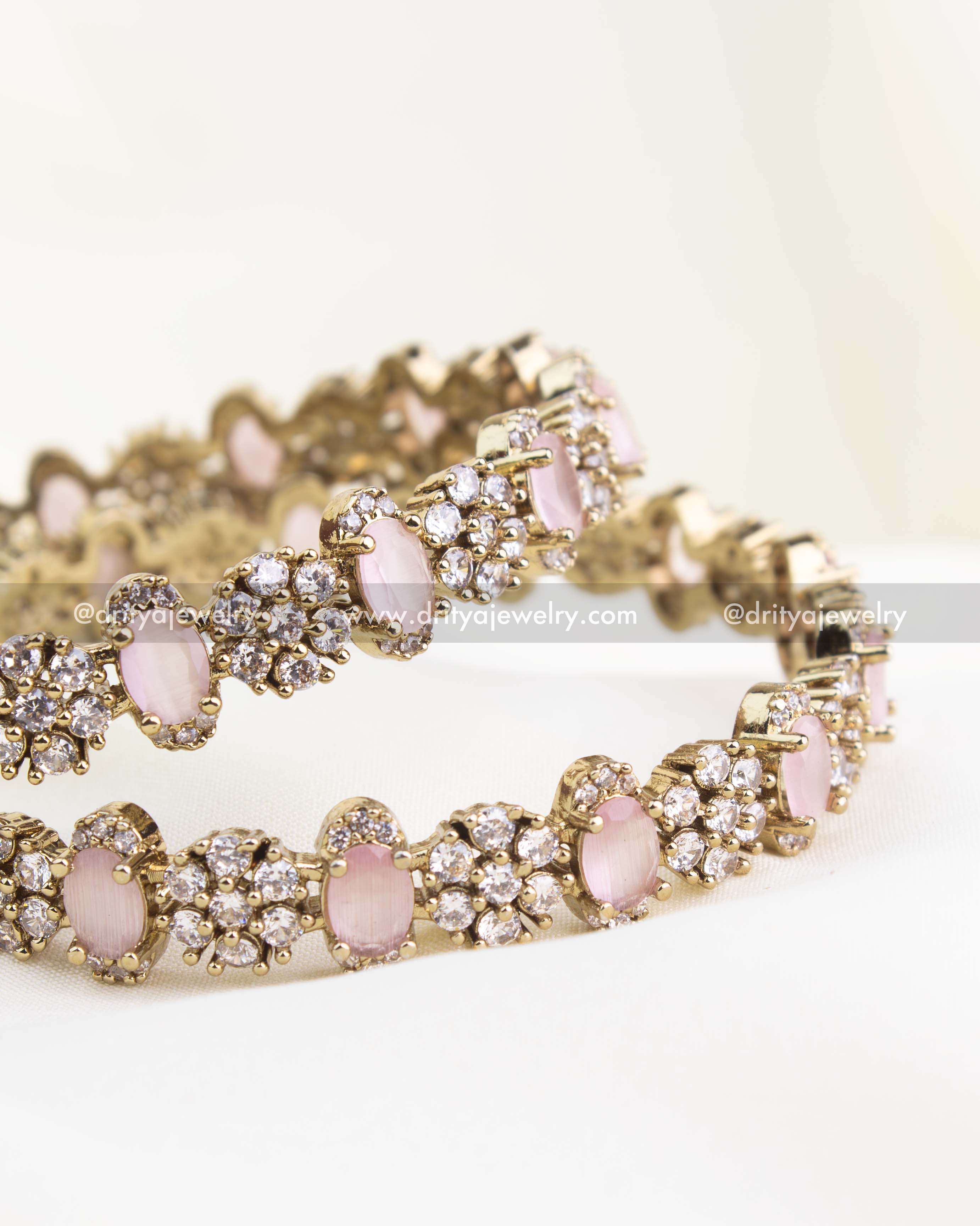 Detailed close-up of blush pink stone Victorian bangles with intricate floral CZ clusters.