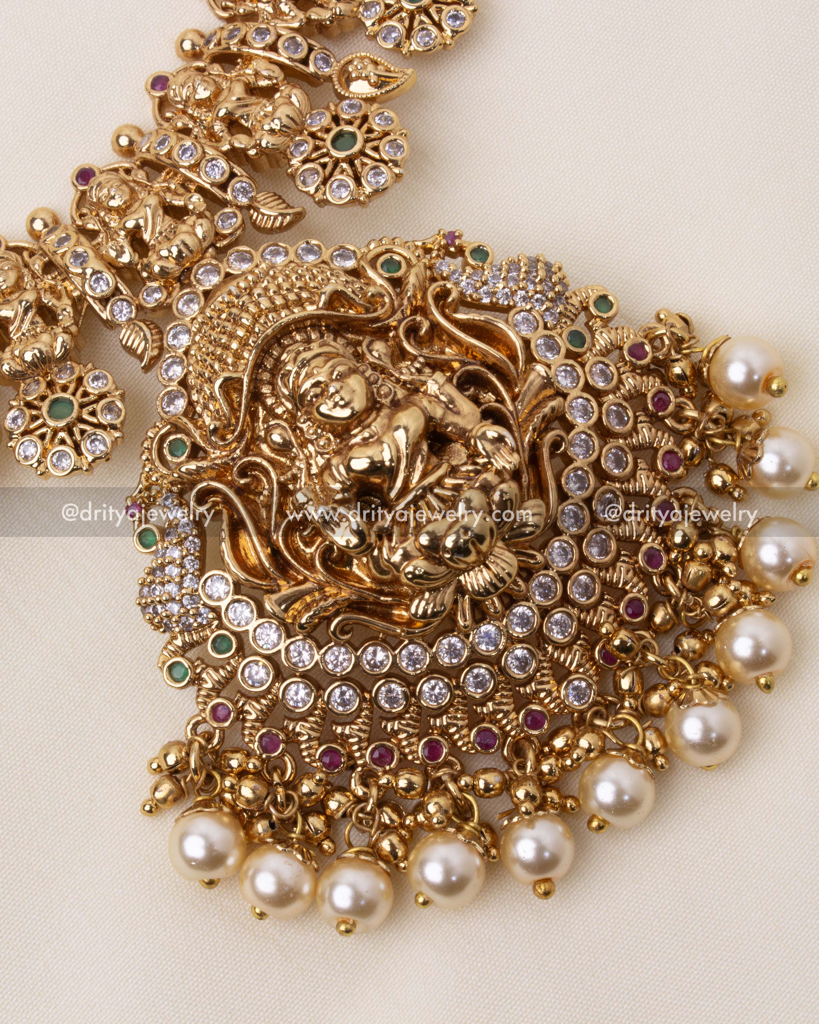 Intricately designed Lakshmi pendant adorned with Polki stones, rubies, and emeralds in antique temple-style polish.