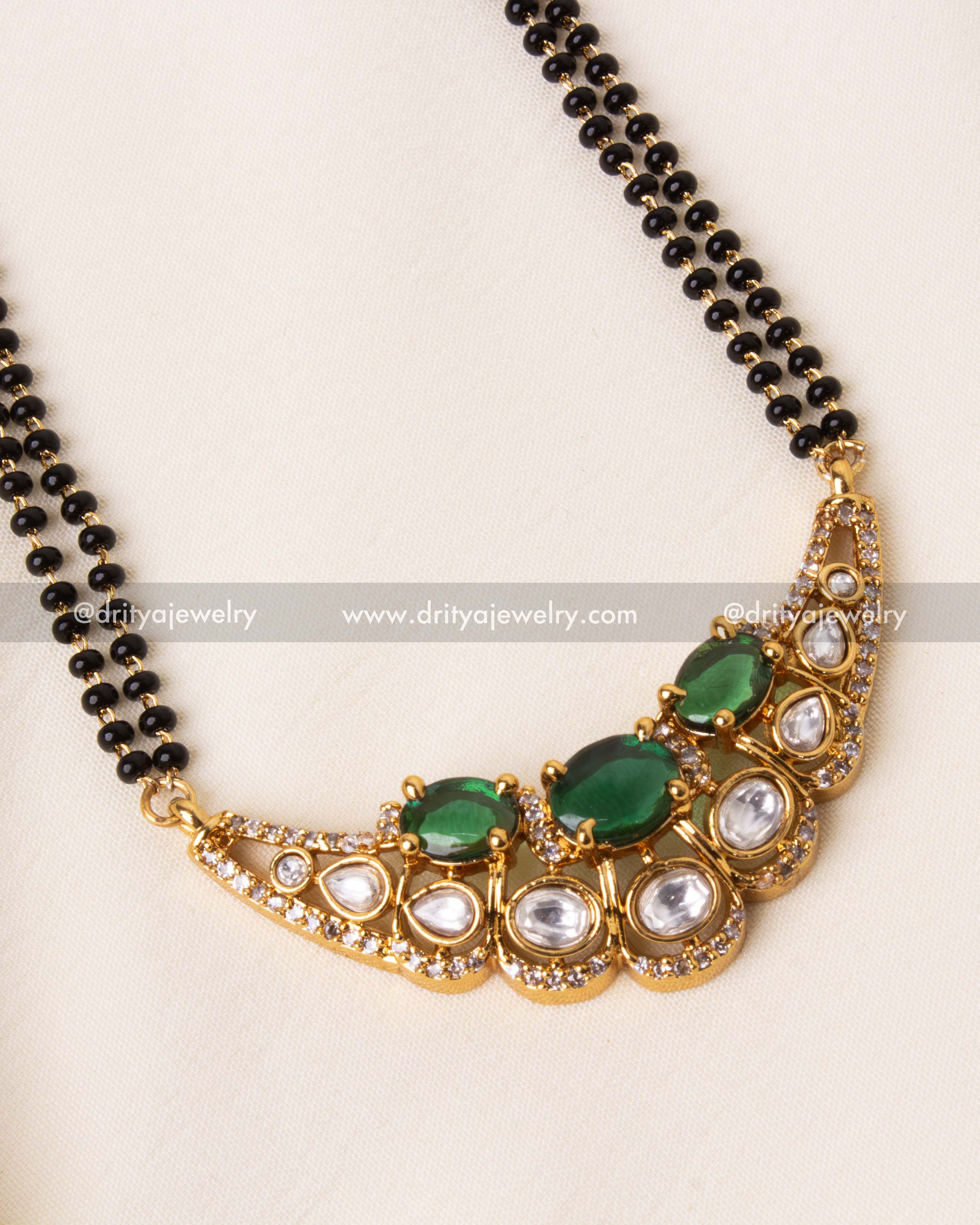 Detailed view of green moissanite stone pendant with kundan and CZ embellishments.