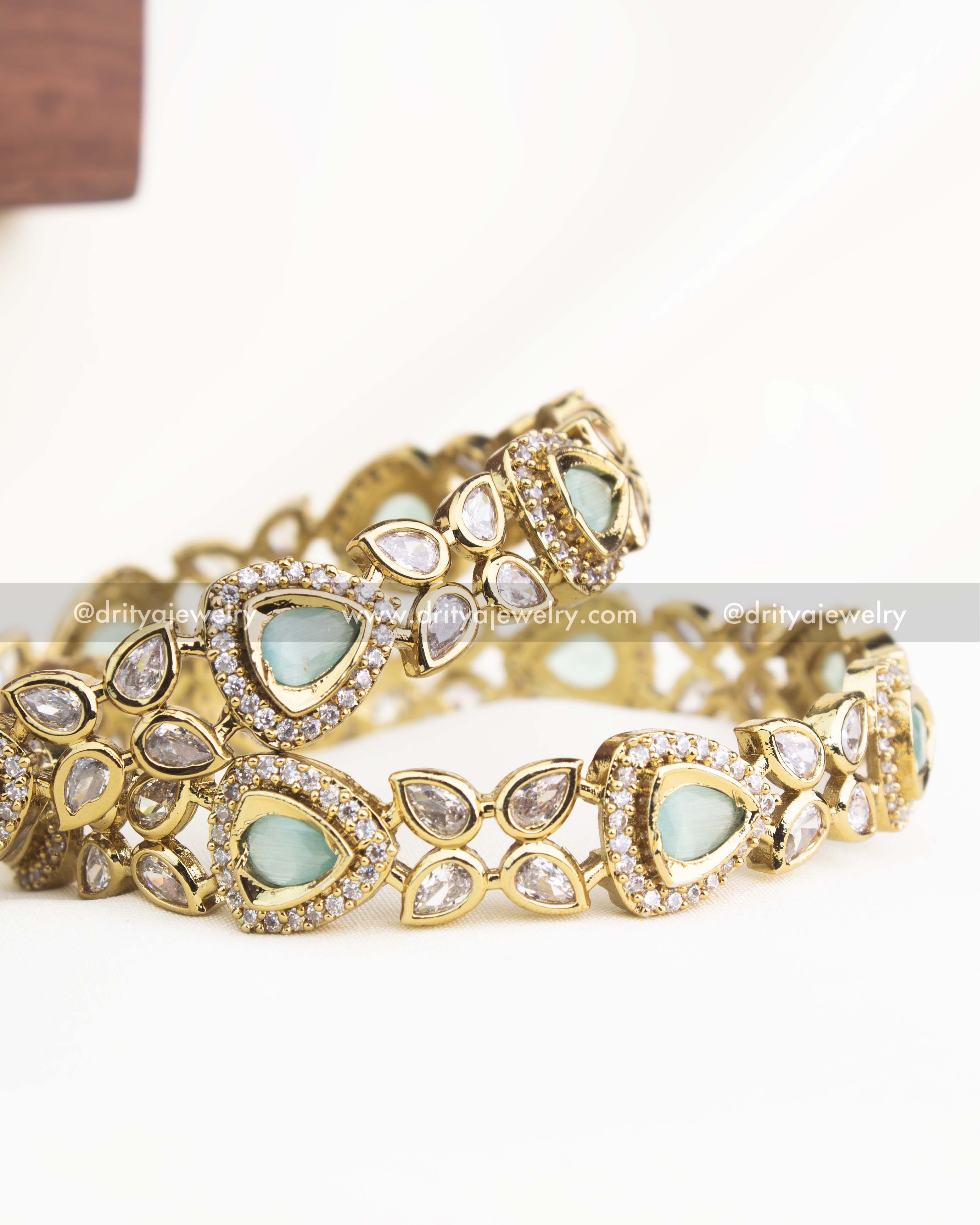 Detailed shot highlighting mint green stones and shimmering AD accents in gold-plated Victorian bangles.