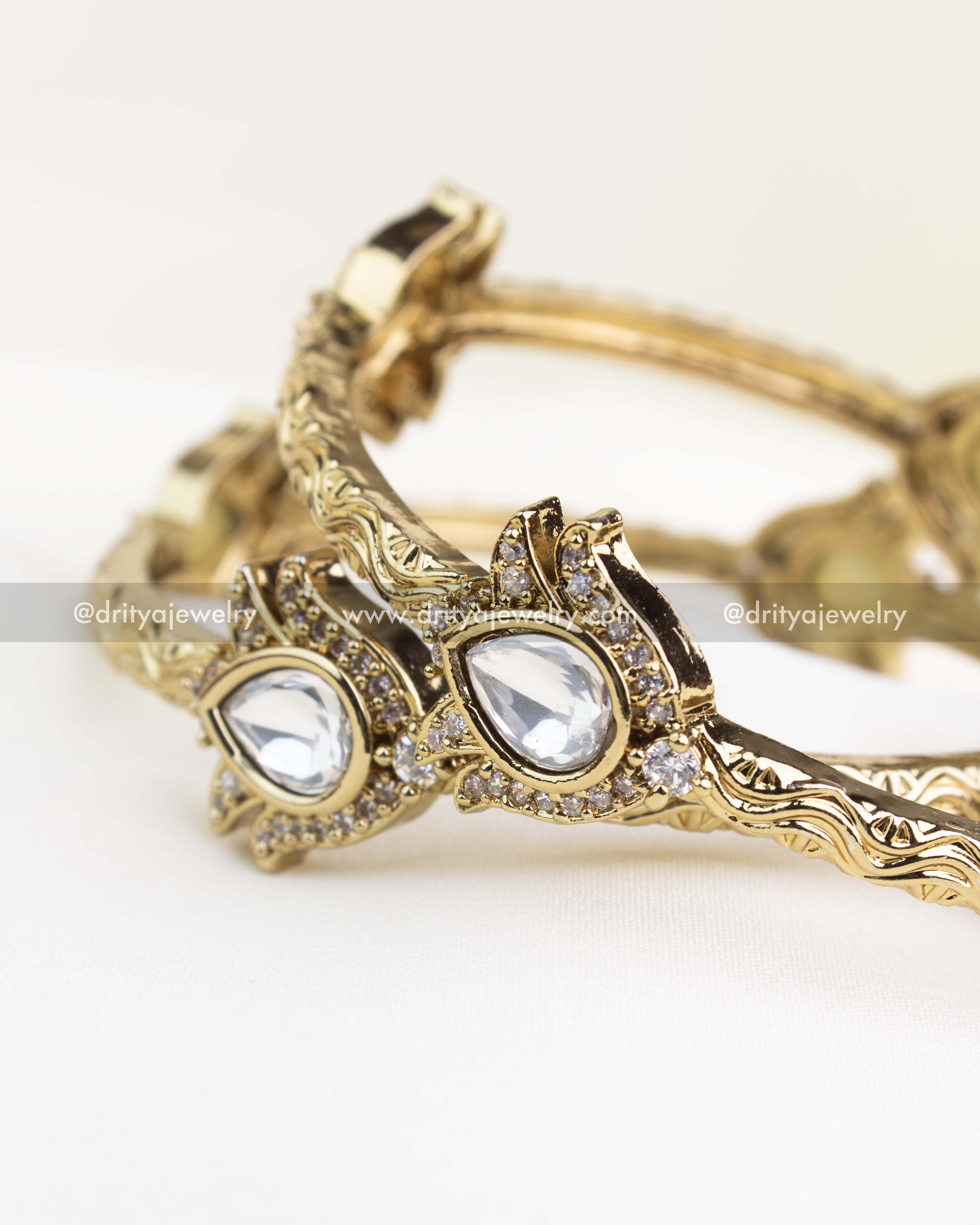 White polki-stone kada in antique gold polish with CZ border and intricate wave pattern.