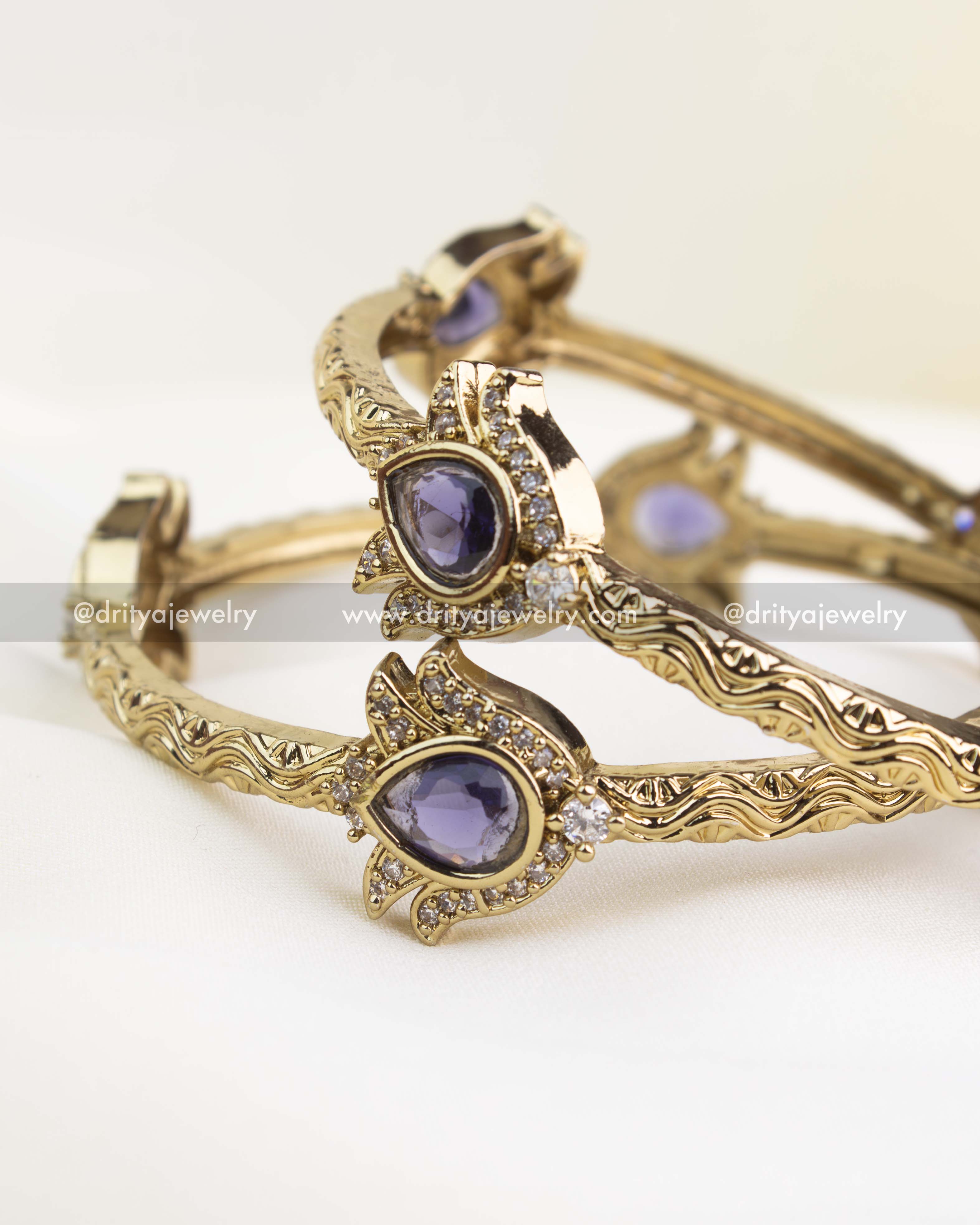 Premium antique kada showcasing violet stone centerpiece and wavy embossed edges.
