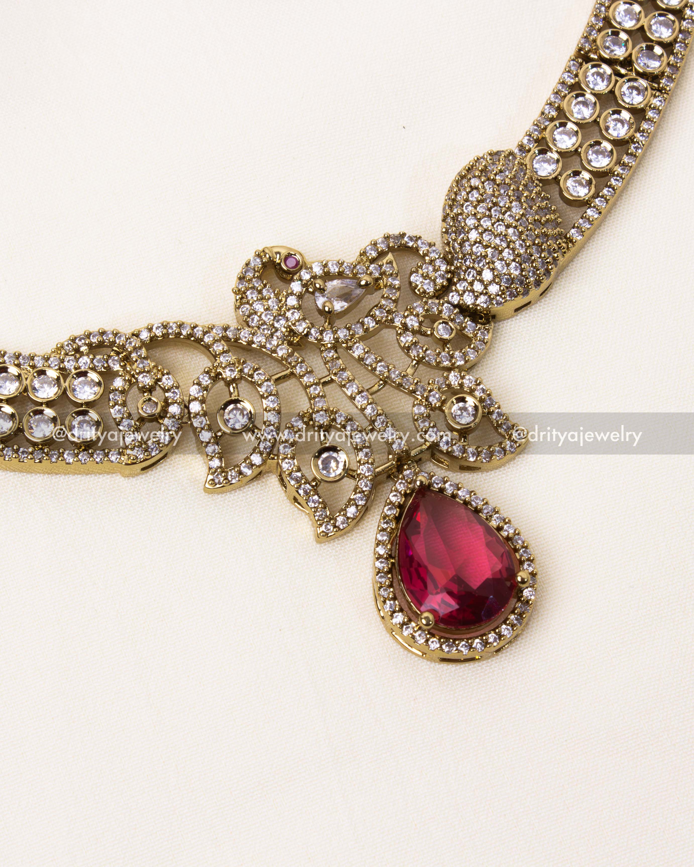 Intricate detailing of the peacock motif with ruby red centerpiece in Victorian finish.