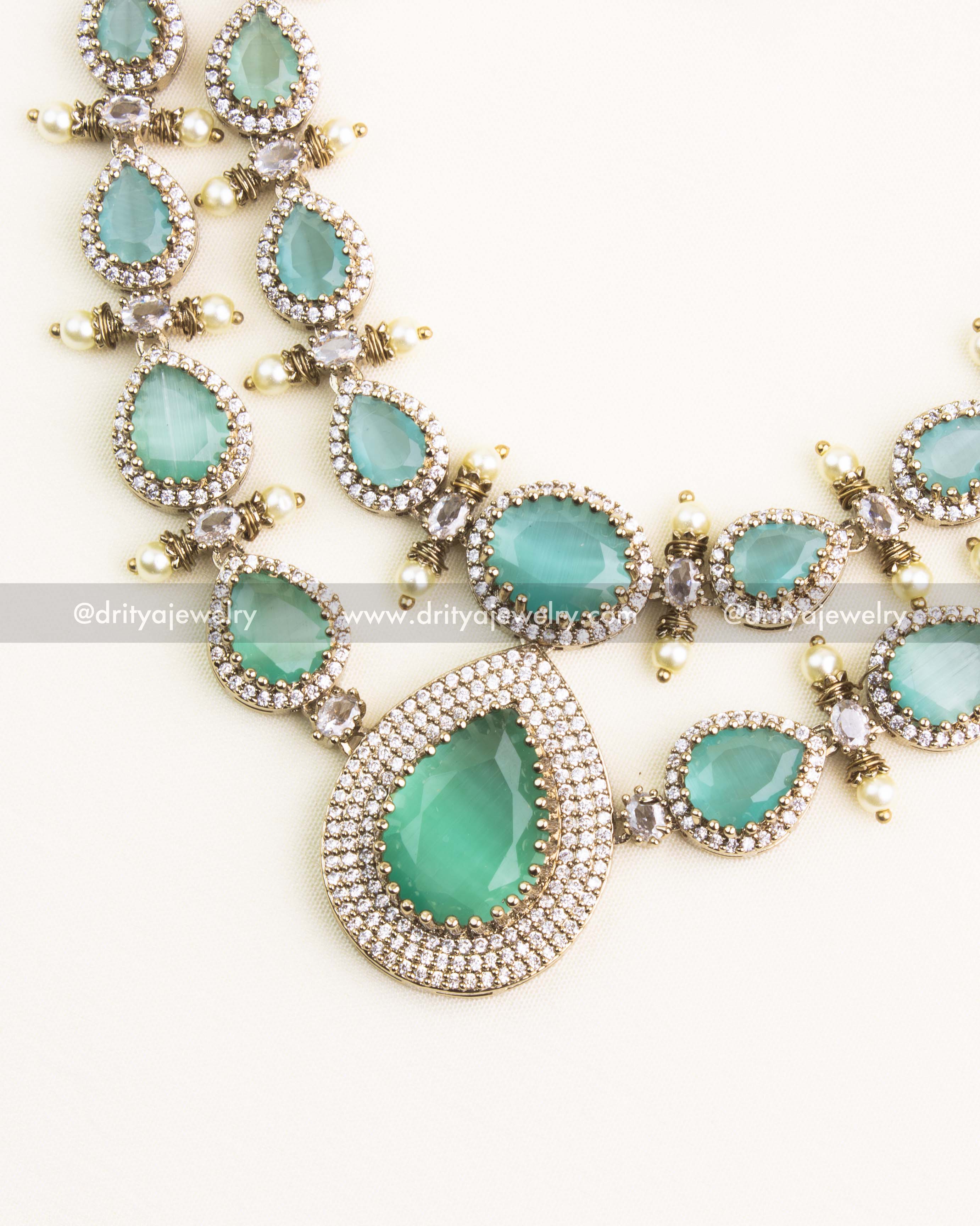 Detailed close-up of the mint green tear-drop pendant with double-layer CZ diamond setting.