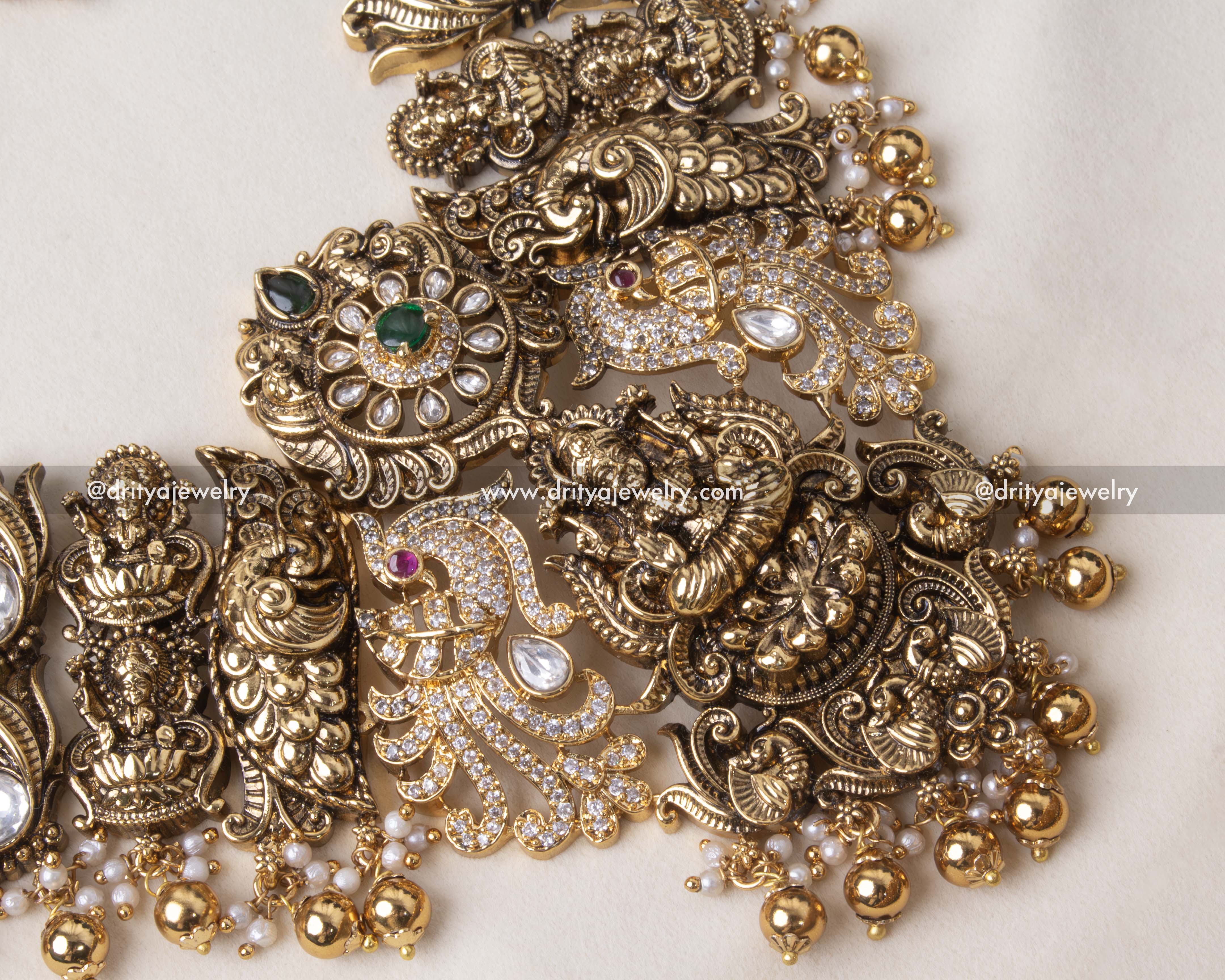 Close-up of Lakshmi Devi motif on the long necklace pendant with emerald beads.