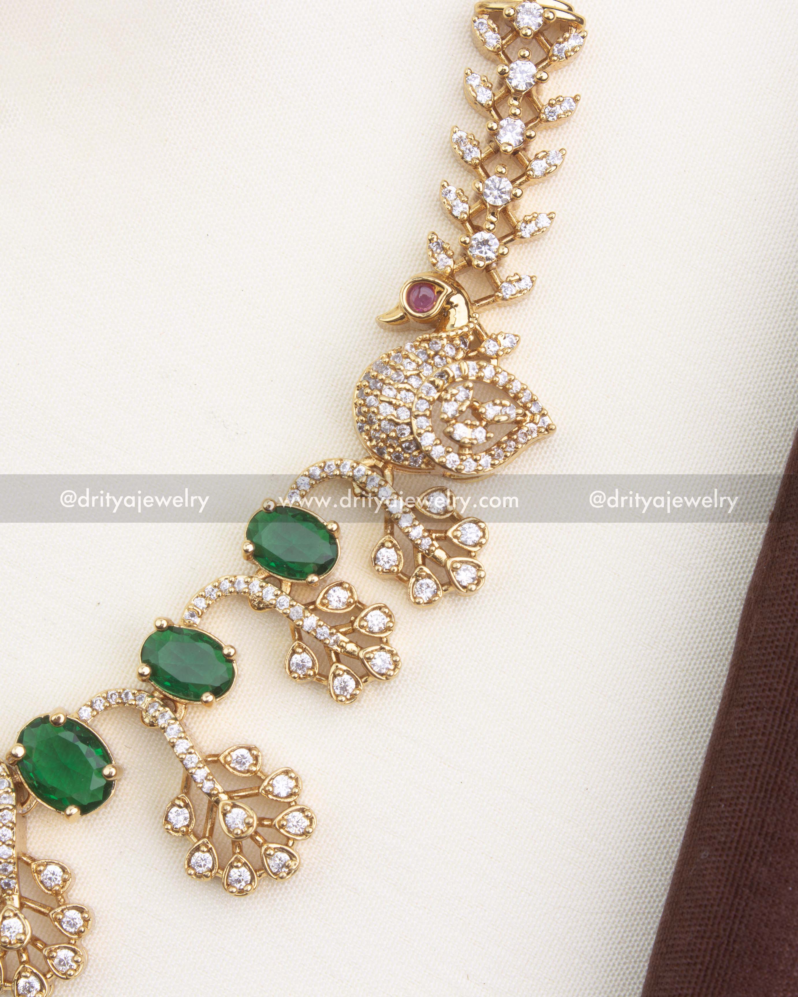 Close view of peacock detailing and sparkling CZ stones in emerald variant necklace set.