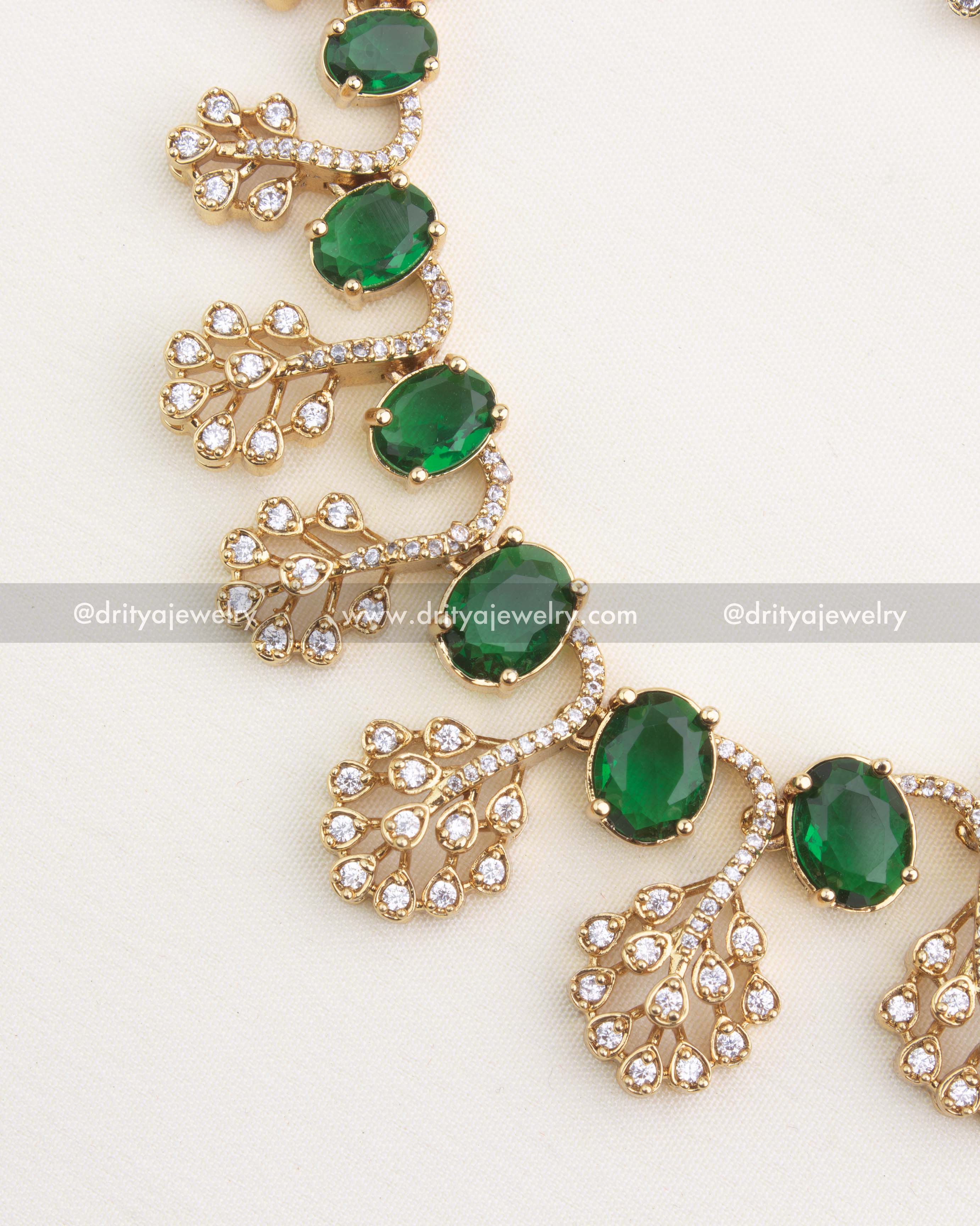 Close view of peacock detailing and sparkling CZ stones in emerald variant necklace set.