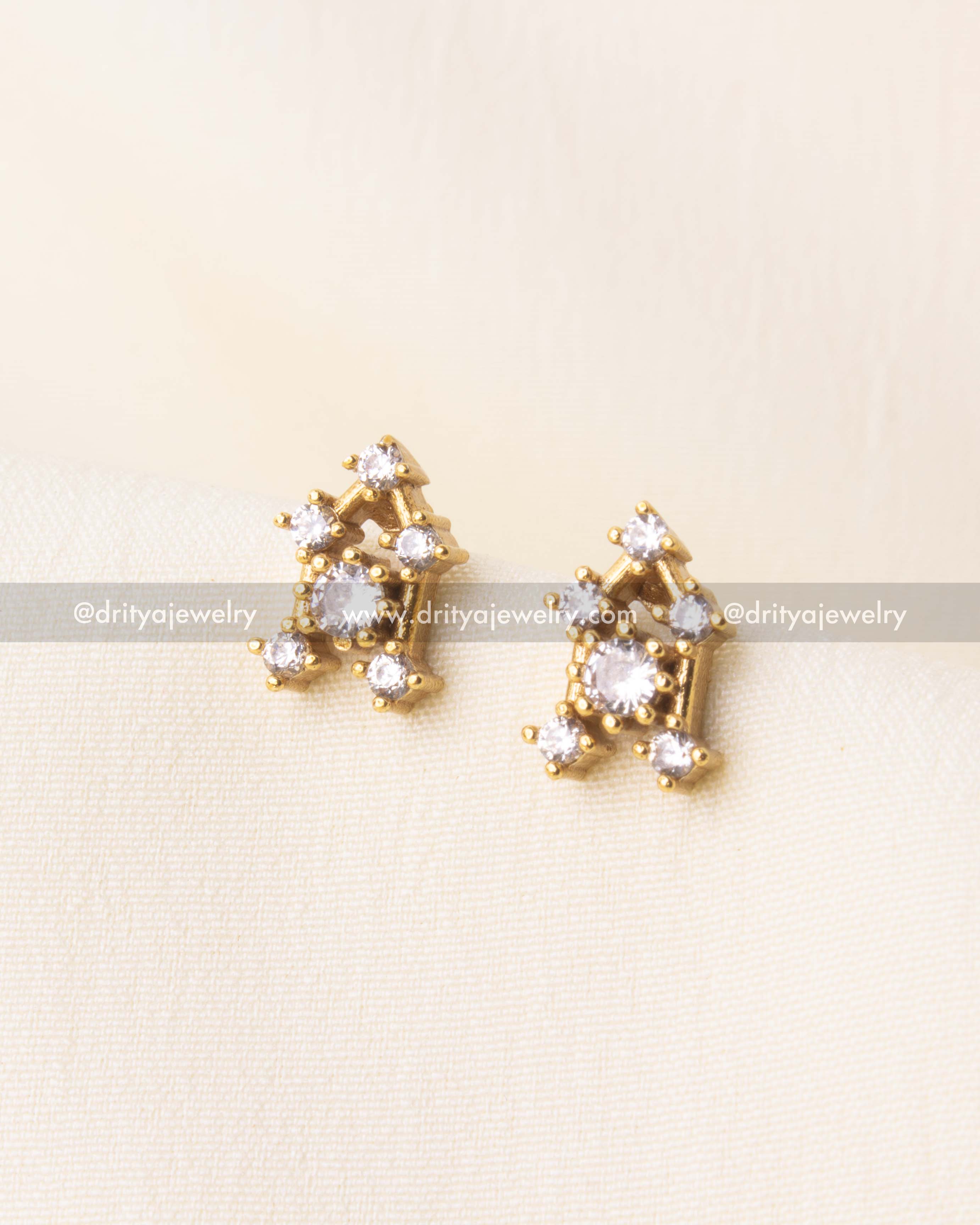 Matching earrings featuring cluster-style CZ stones with gold-tone backing.