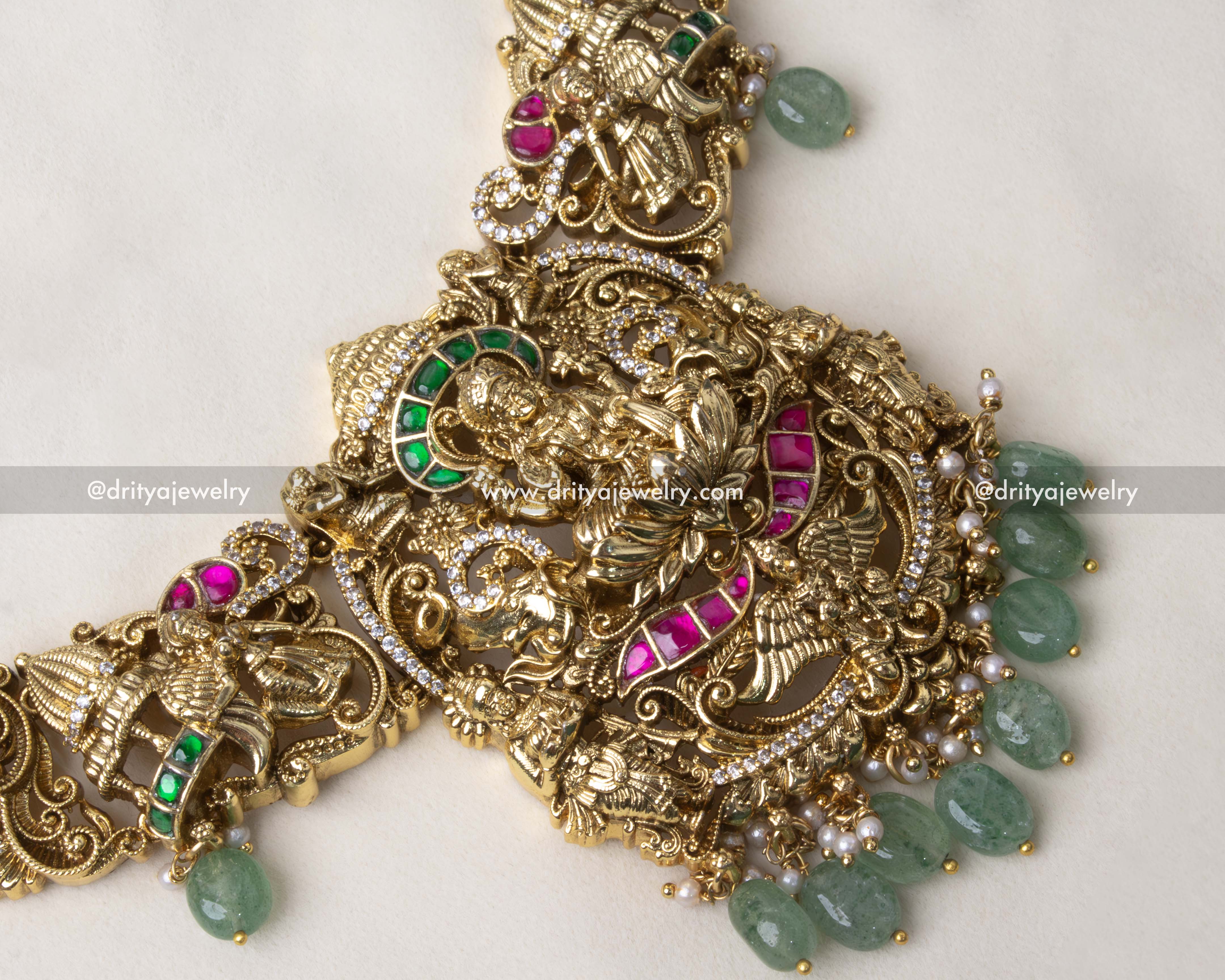 Close-up of a deity pendant with pearls, kemp stones, and intricate nakshi work.