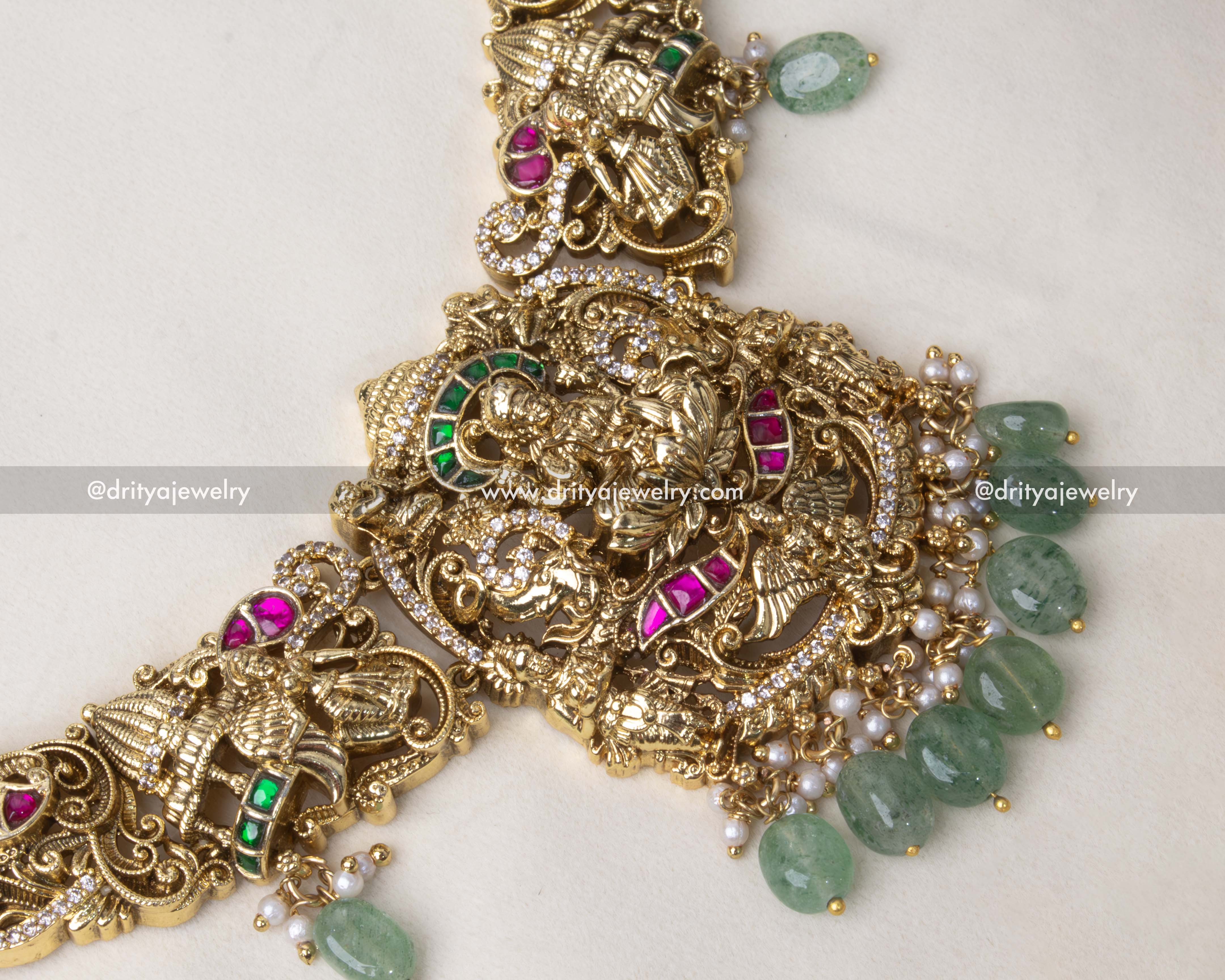 Close-up of a deity pendant with pearls, kemp stones, and intricate nakshi work.