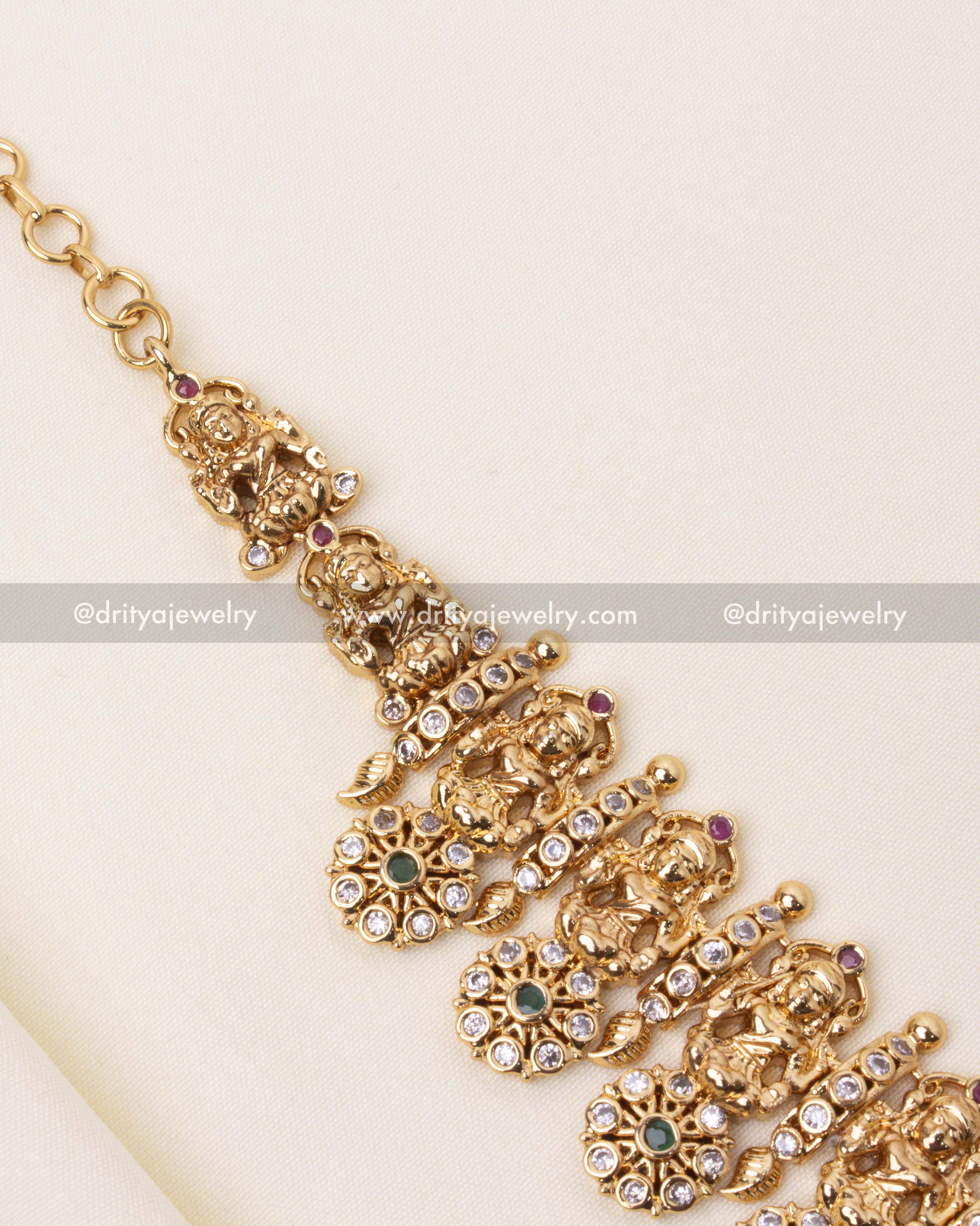 Traditional necklace showcasing floral motifs and goddess figurines with colorful stones.