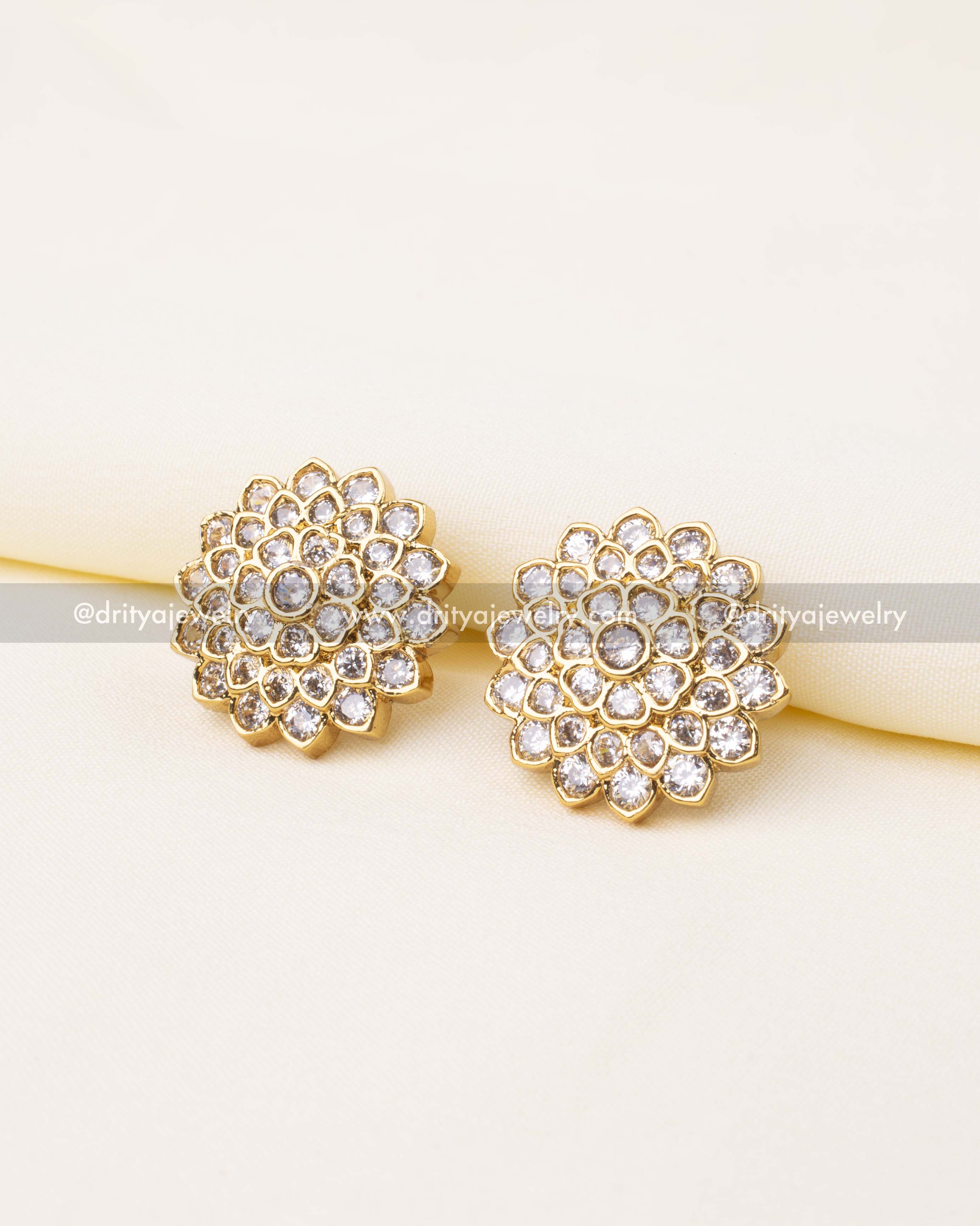 Elegant diamond-look floral stud earrings with multiple layers of stones and gold finish.