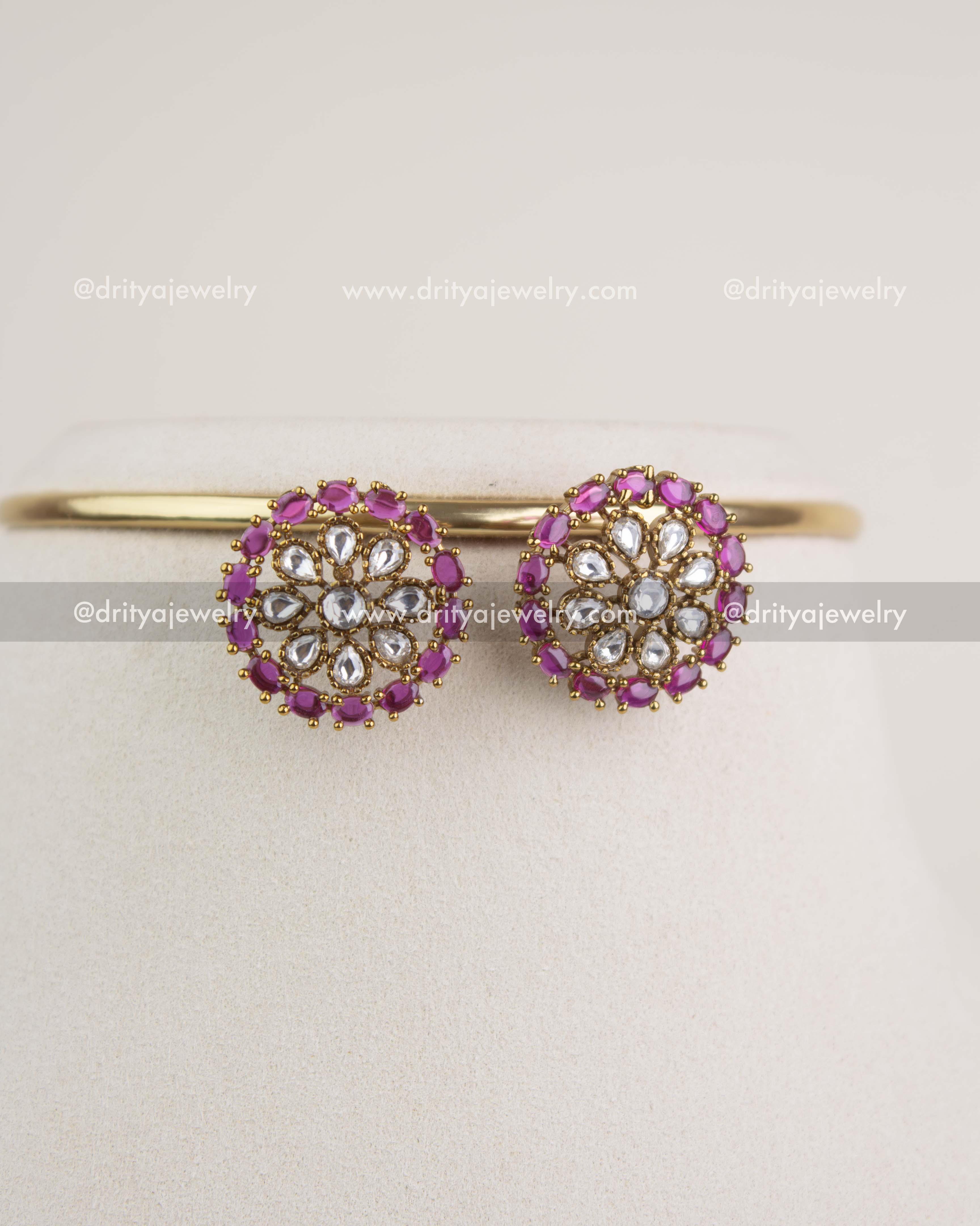 Floral polki kundan stud earrings with ruby stone border from the matching choker set.
