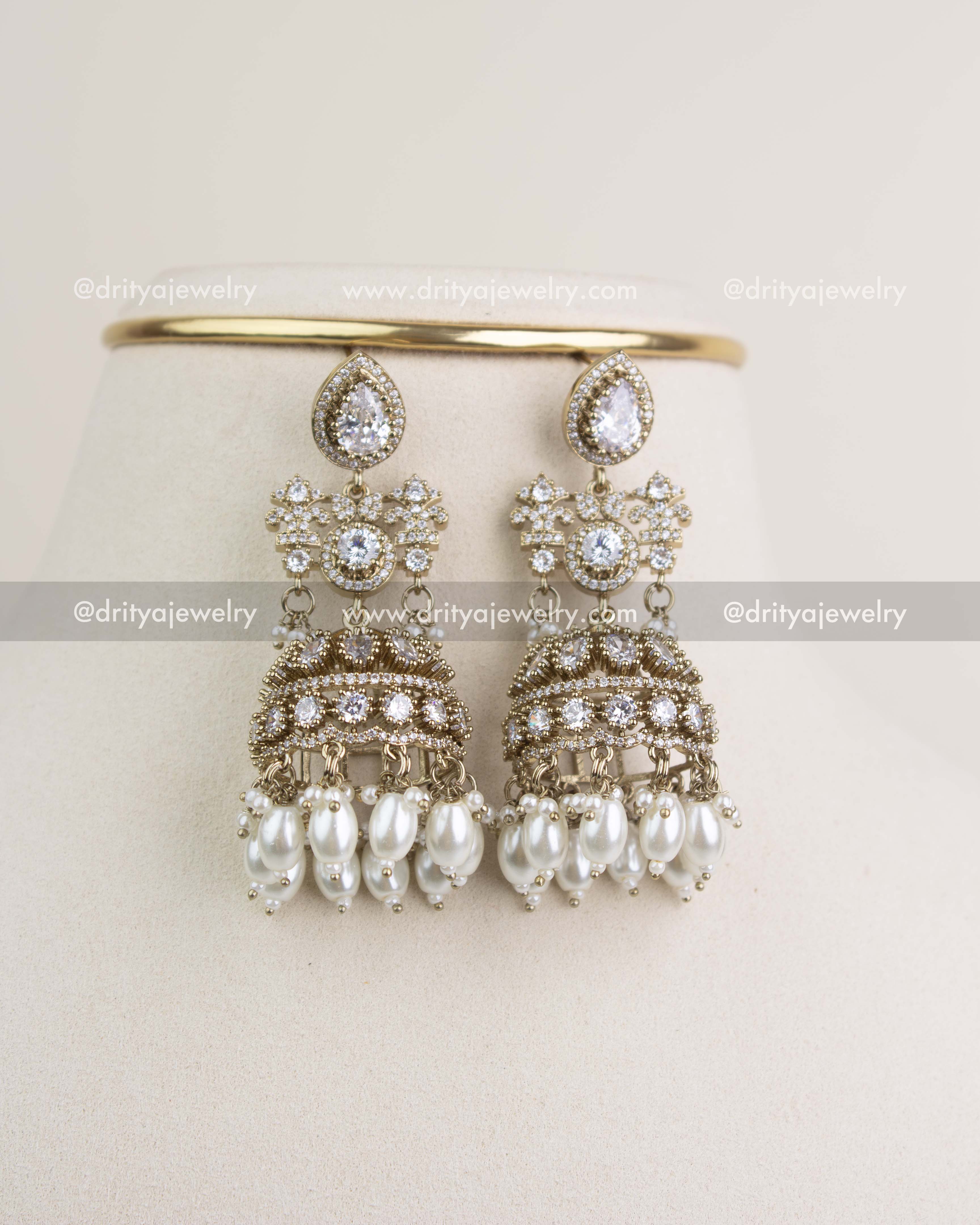 Matching big-size jhumka earrings with Russian emerald stones, AD crystals, and dangling green beads.