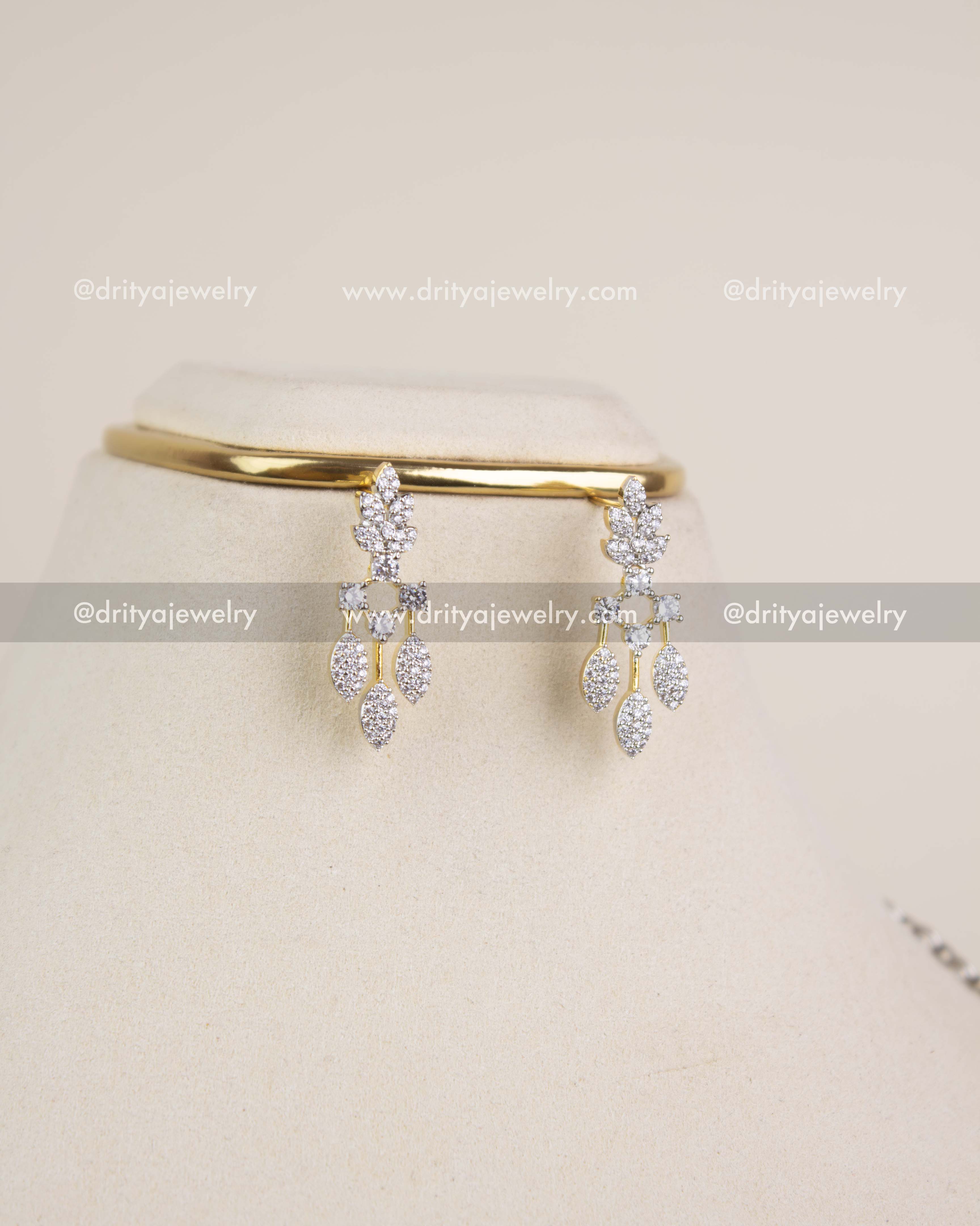 Drop earrings with CZ diamond-replica leaf design in gold polish.
