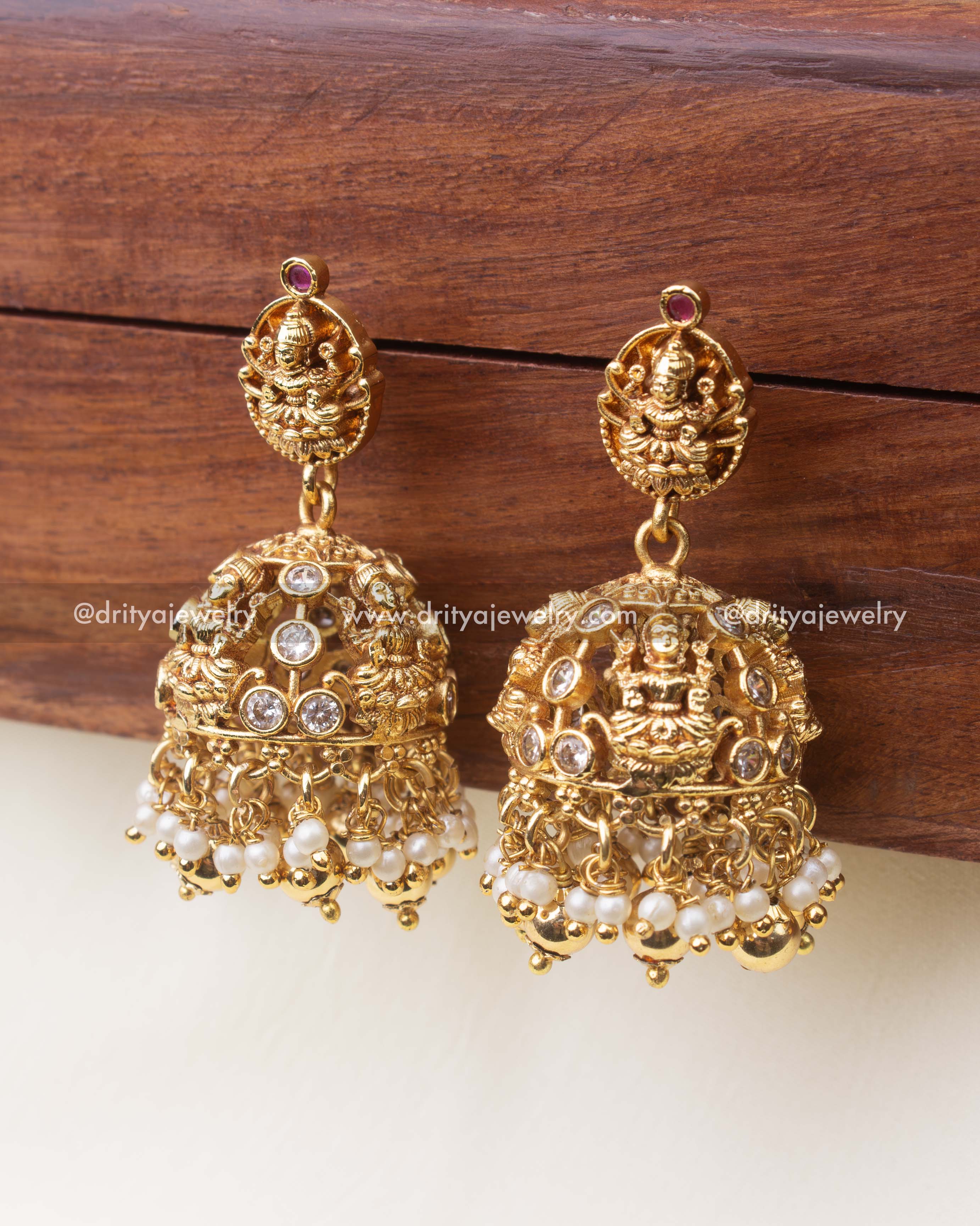 Matching temple jhumka earrings with Lakshmi design, CZ stones, and pearl drops