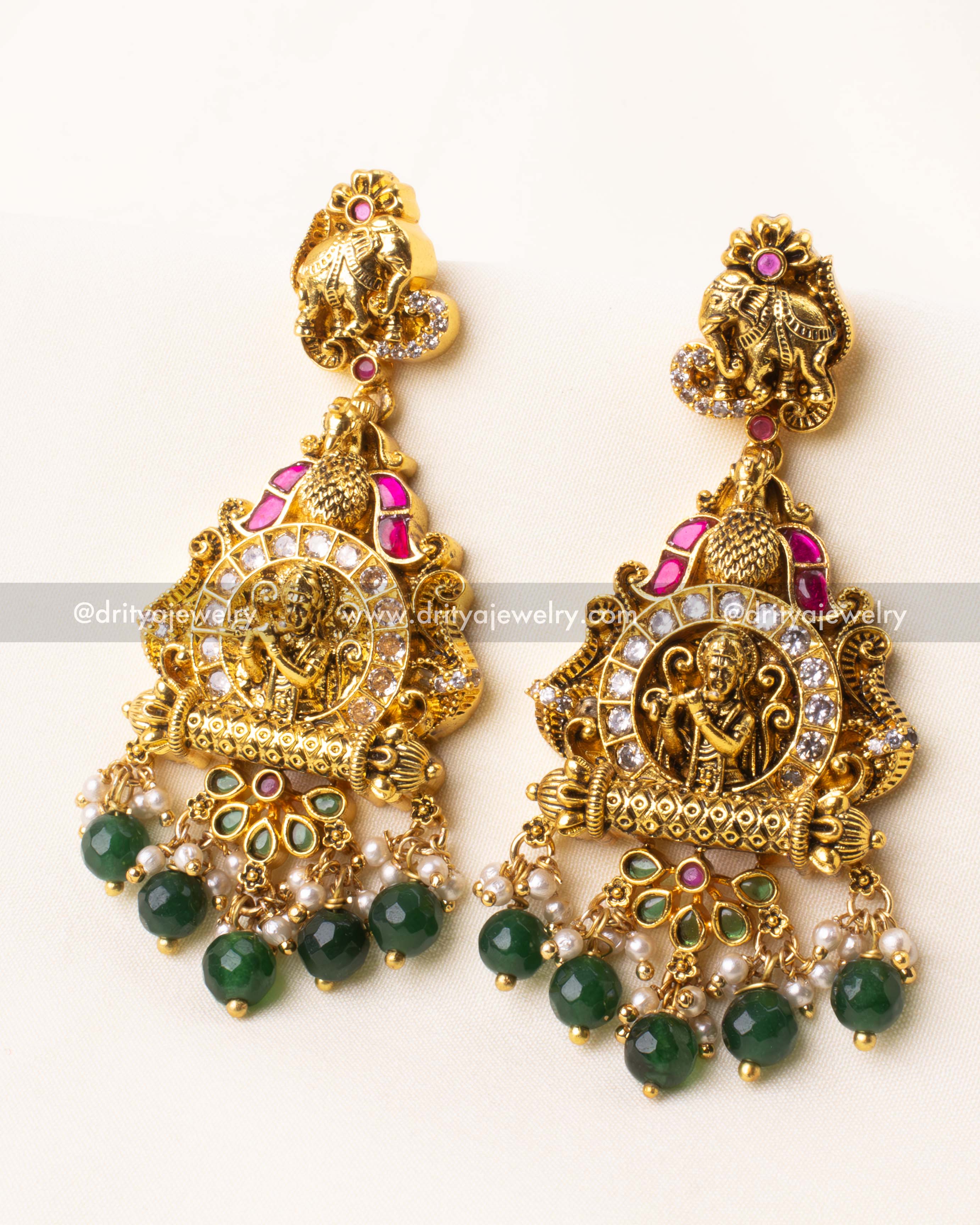 Pair of temple-style earrings with green bead drops and intricate Lakshmi carving.