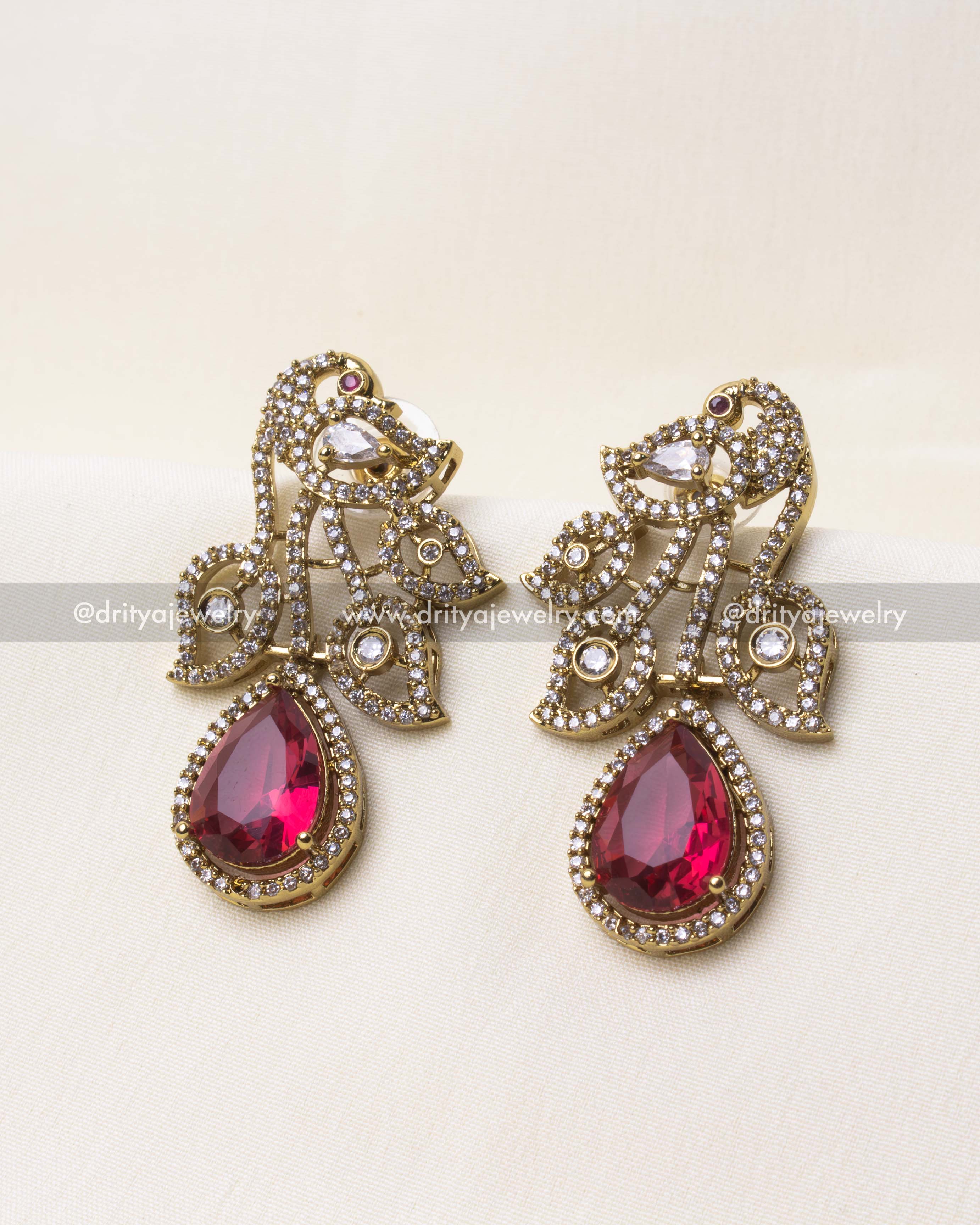 Intricate detailing of the peacock motif with ruby red centerpiece in Victorian finish.