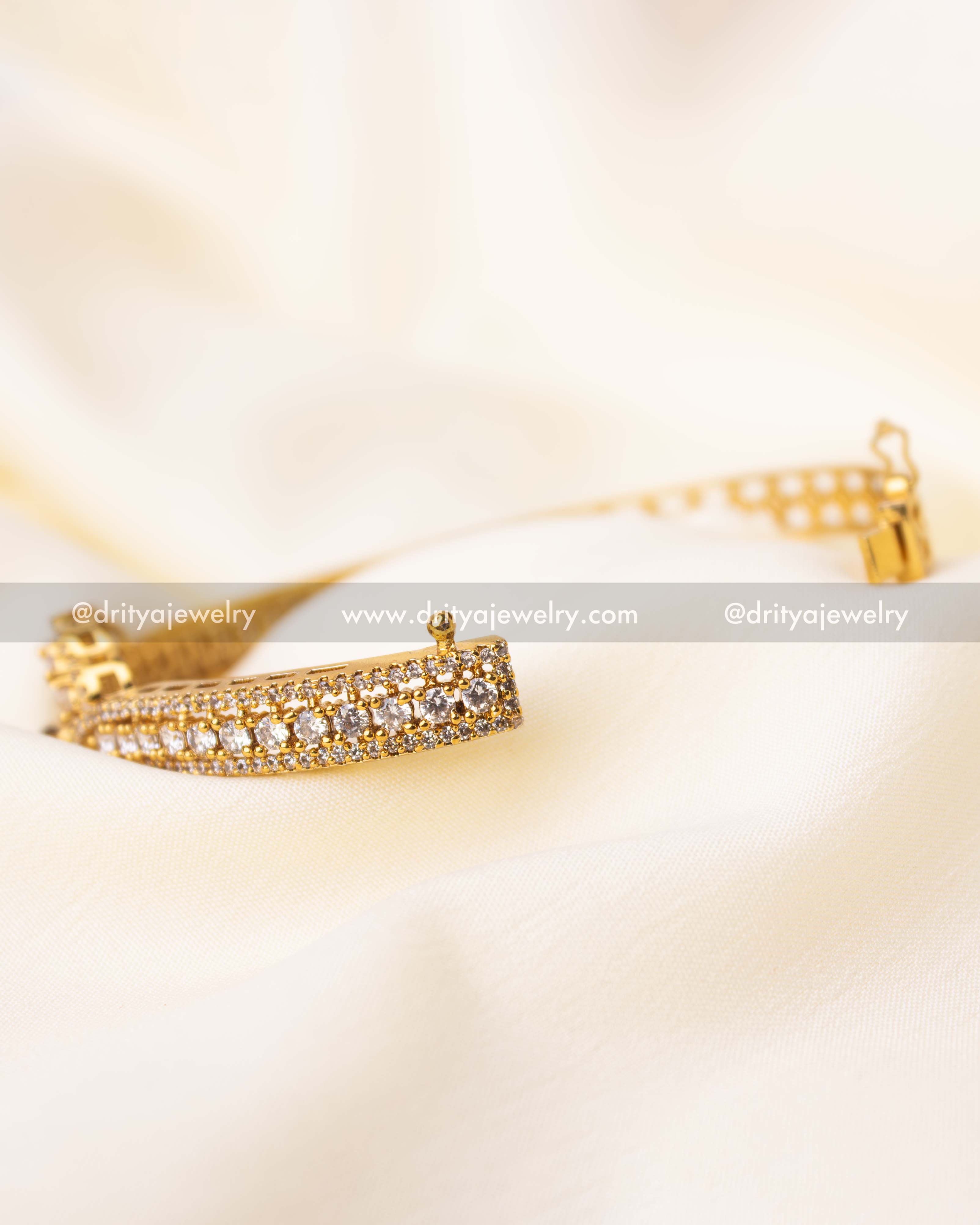 Open kada showcasing brilliant CZ stones and a vibrant ruby centerpiece, ideal for festive wear.