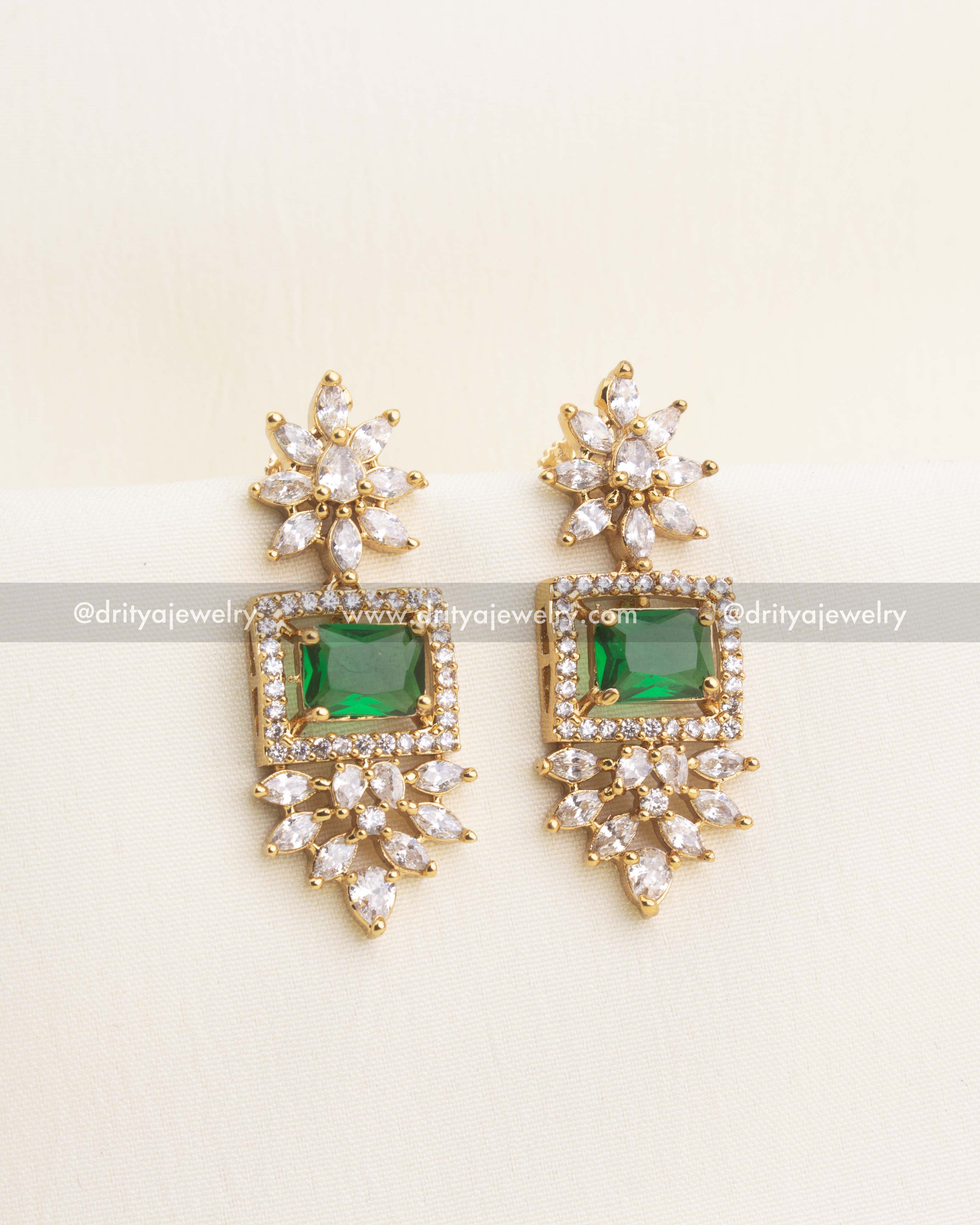Matching earrings featuring emerald green stone and floral CZ arrangements.
