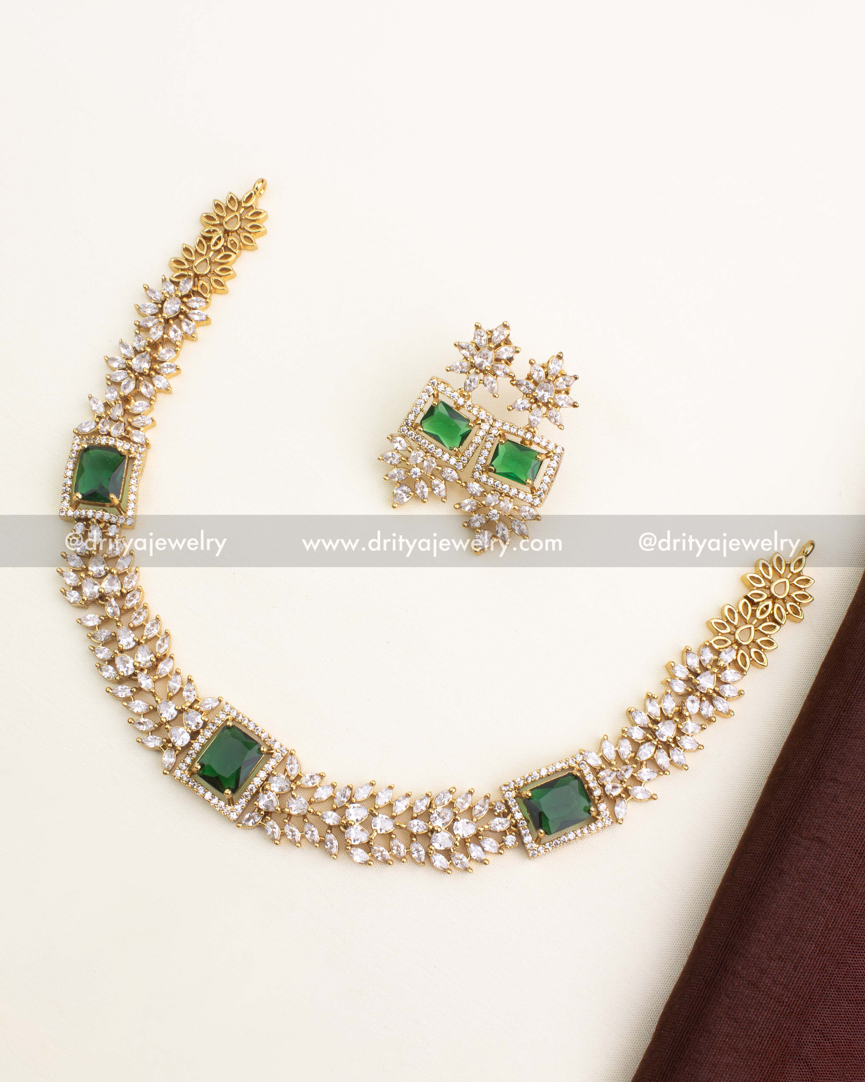 Short necklace set with emerald green square stone and floral CZ chain links, paired with matching earrings.