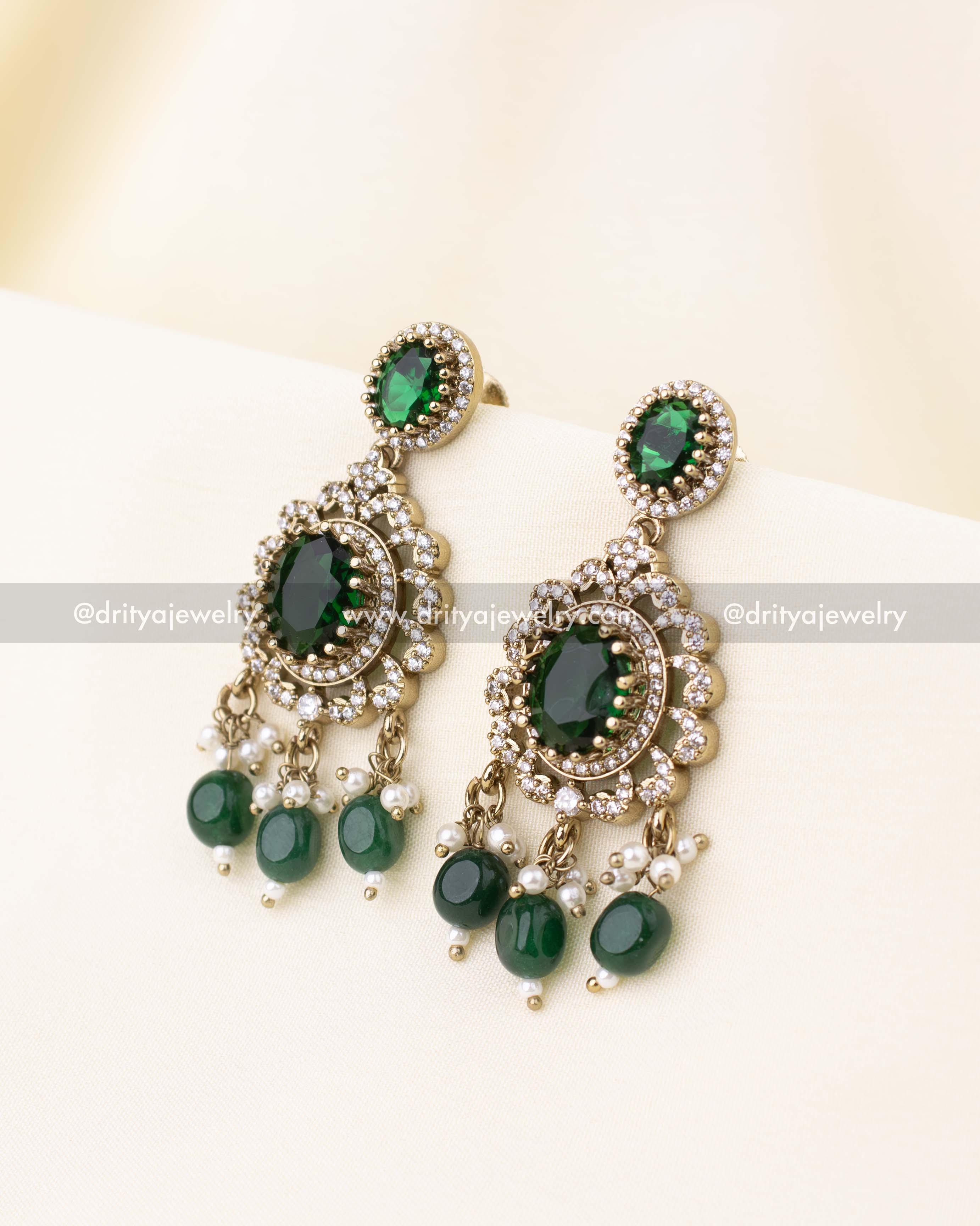 Pair of earrings with emerald green stones and bead tassels.