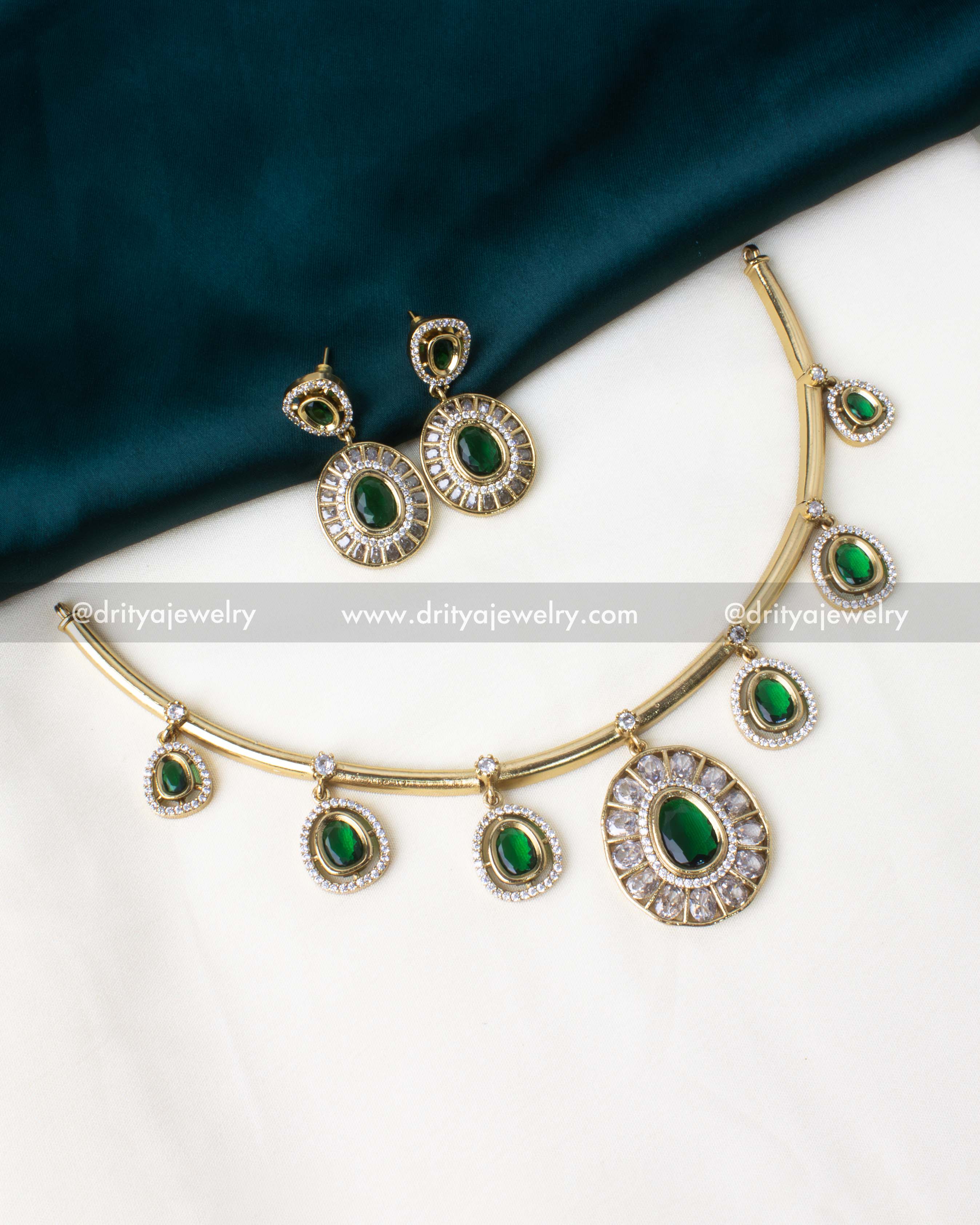 Gold-plated hasli necklace set with emerald green pendants and AD stone accents.
