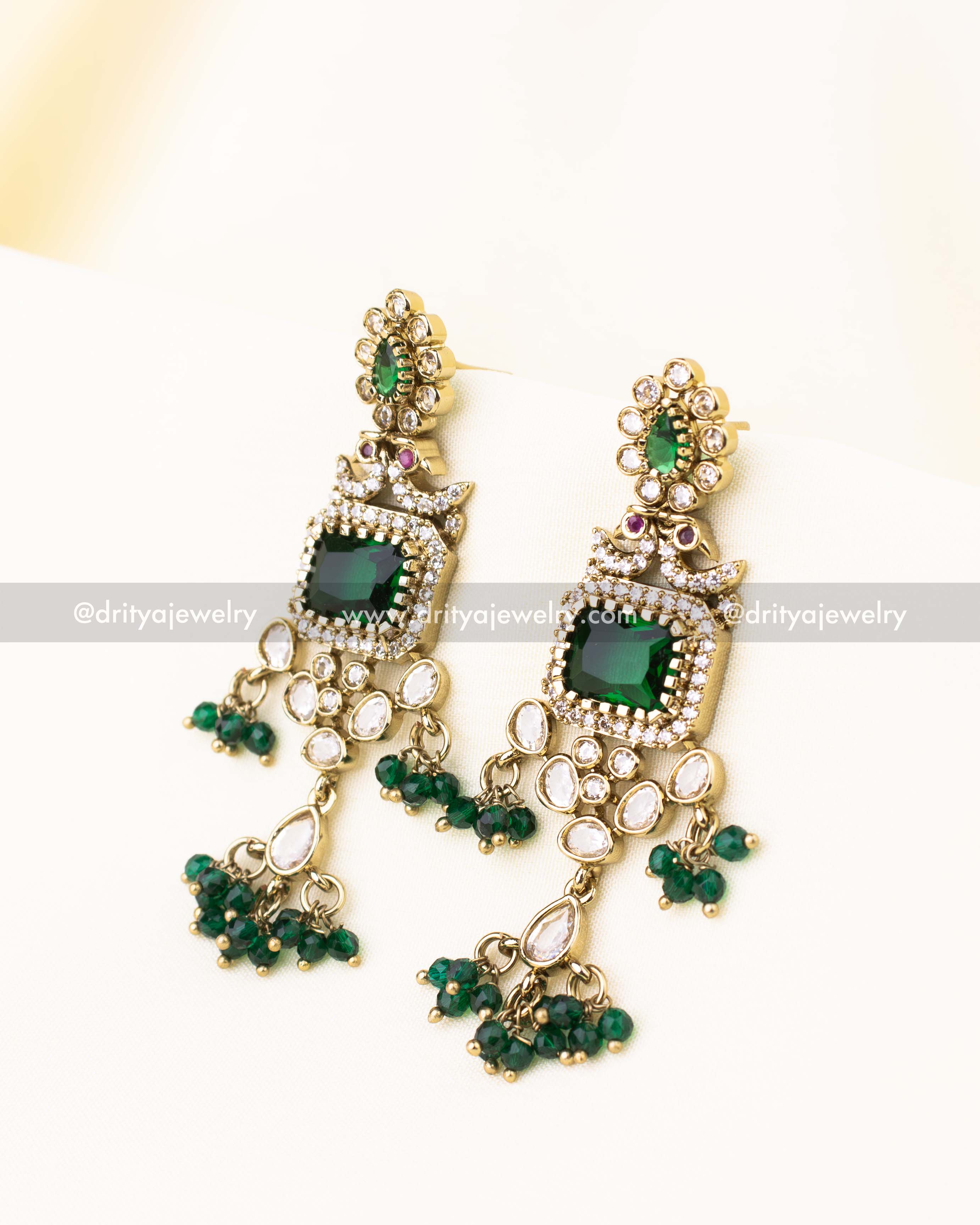 Explore these matching emerald green Kundan earrings, featuring intricate polki settings and cascading bead drops. A striking accessory for special occasions.