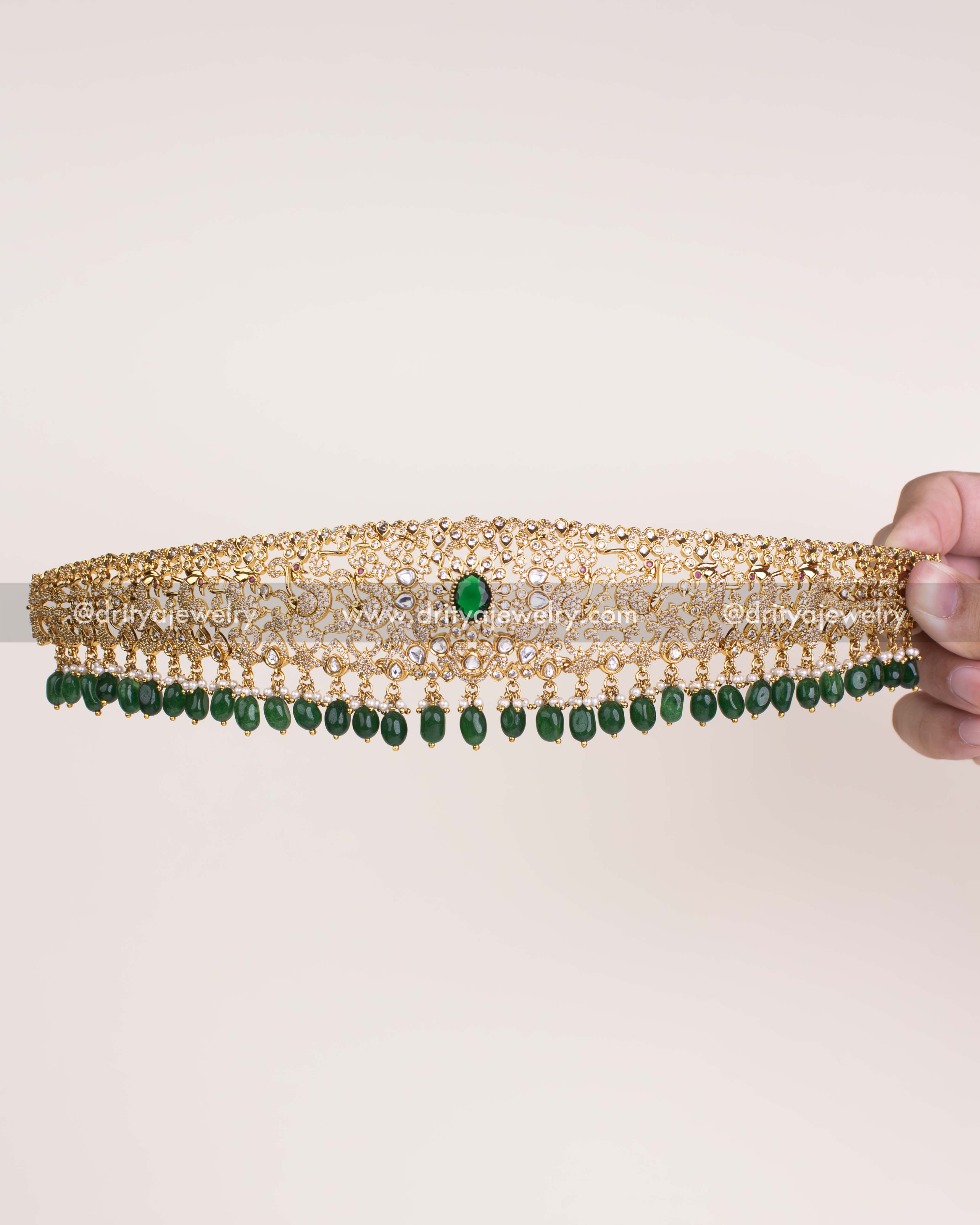 Elegant kundan waist belt with emerald green bead drops and peacock motifs.