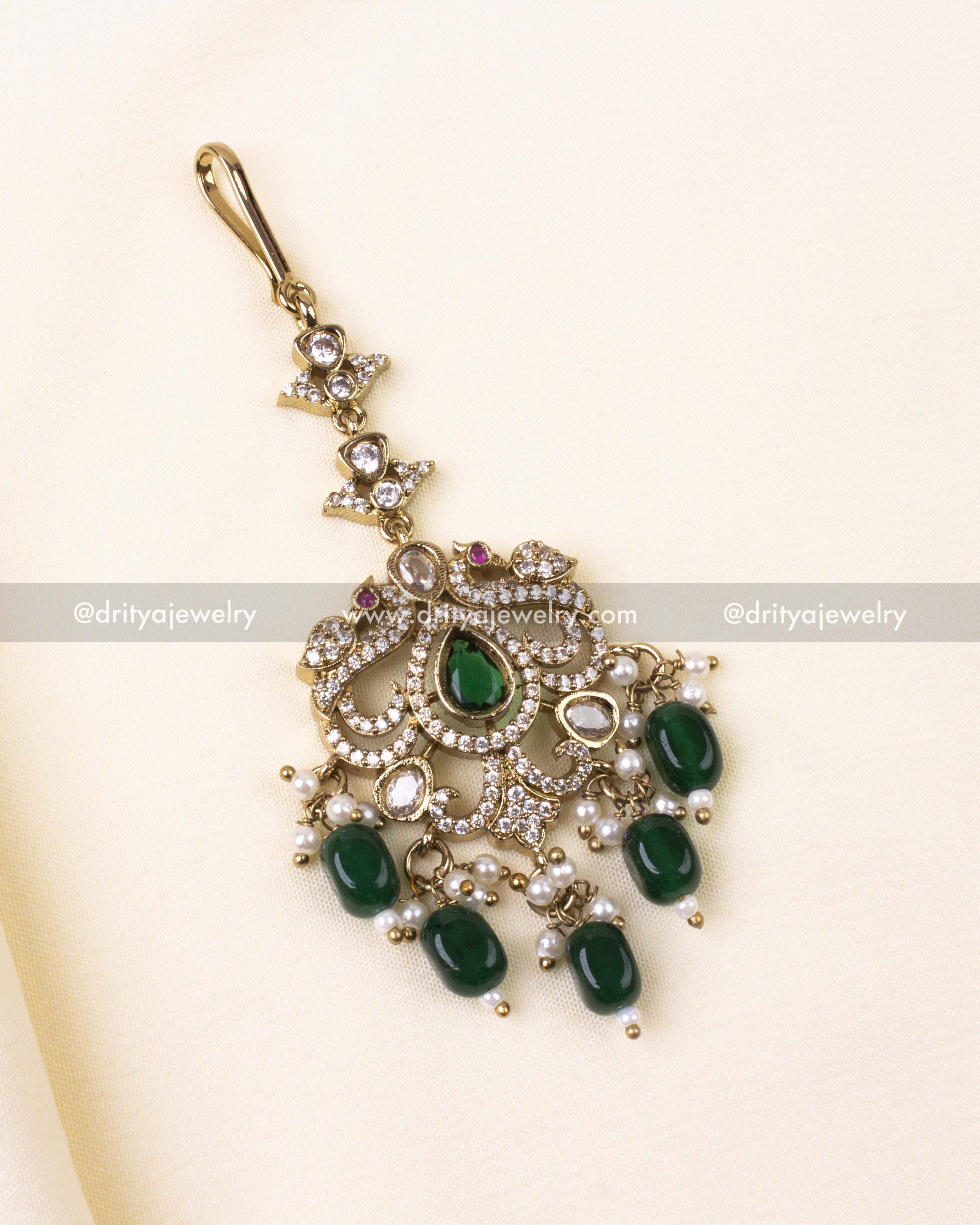 Victorian tikka in antique gold with emerald green stones and pearl accents.