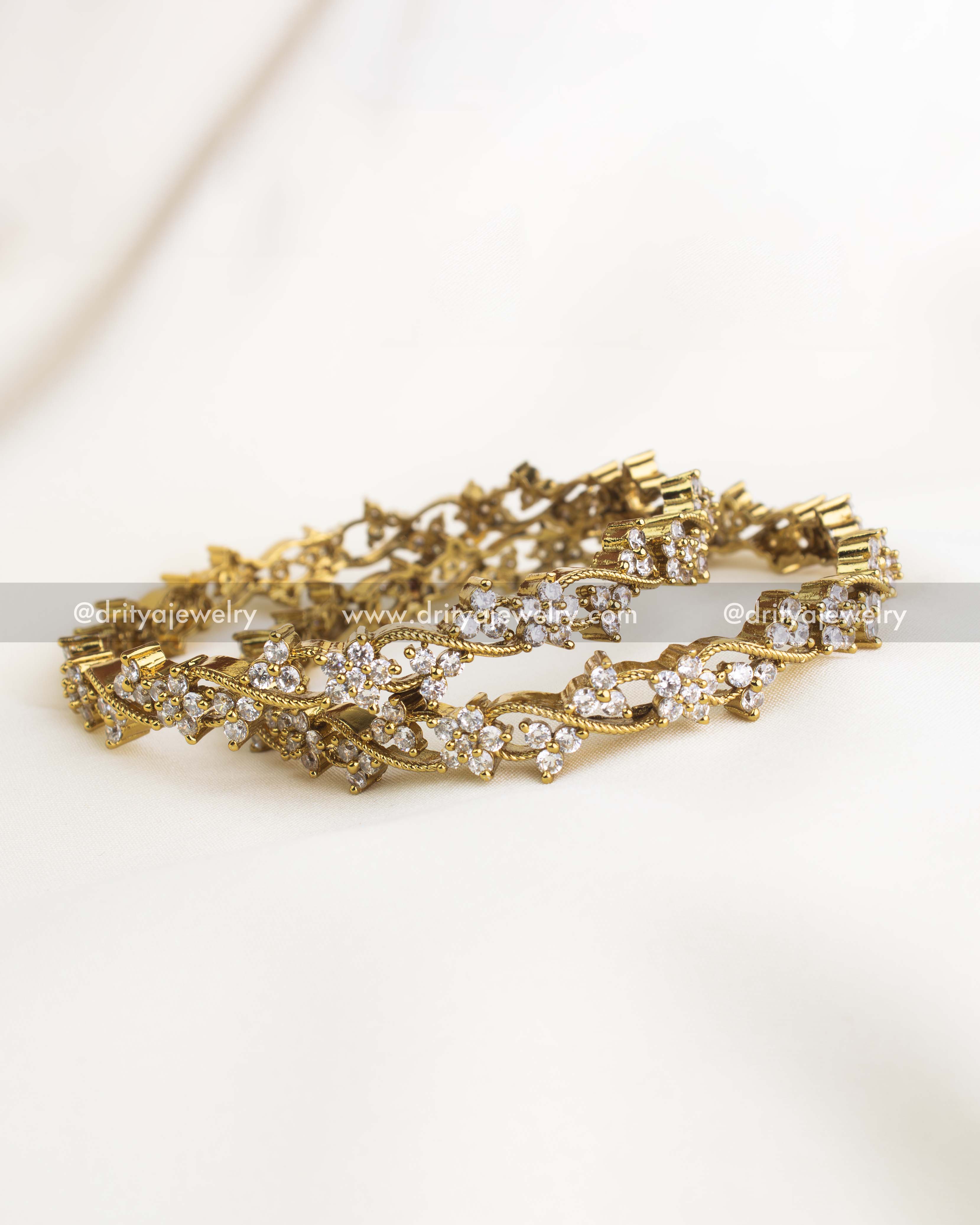 Premium gold-plated floral climber bangles with AD stones and twisted vine design by Dritya Jewelry.