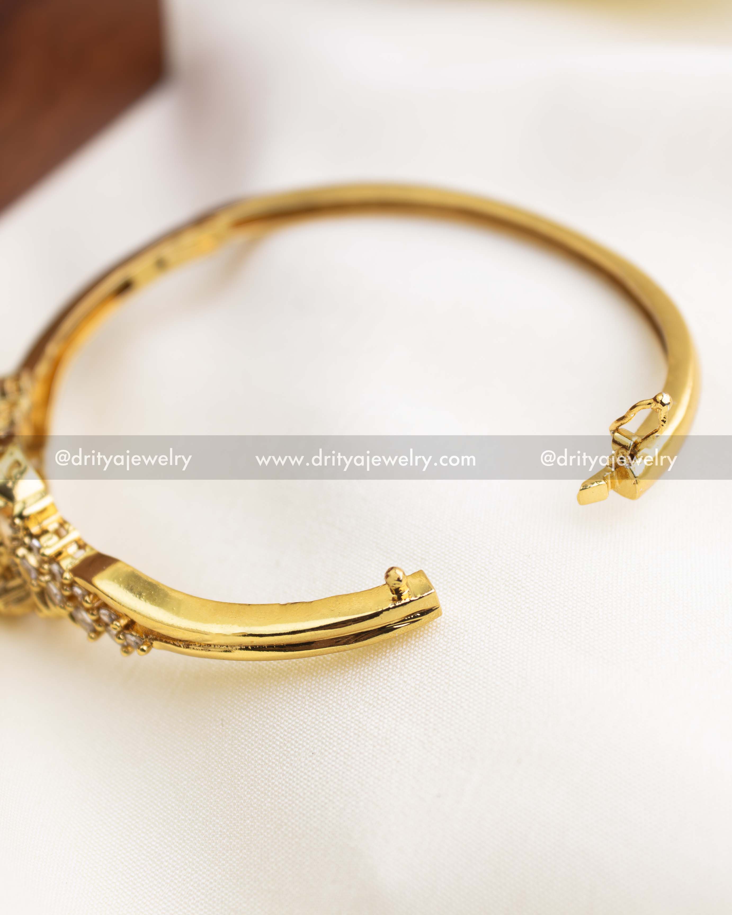 Temple jewelry kada with openable clasp design for easy wear, finished in gold polish.