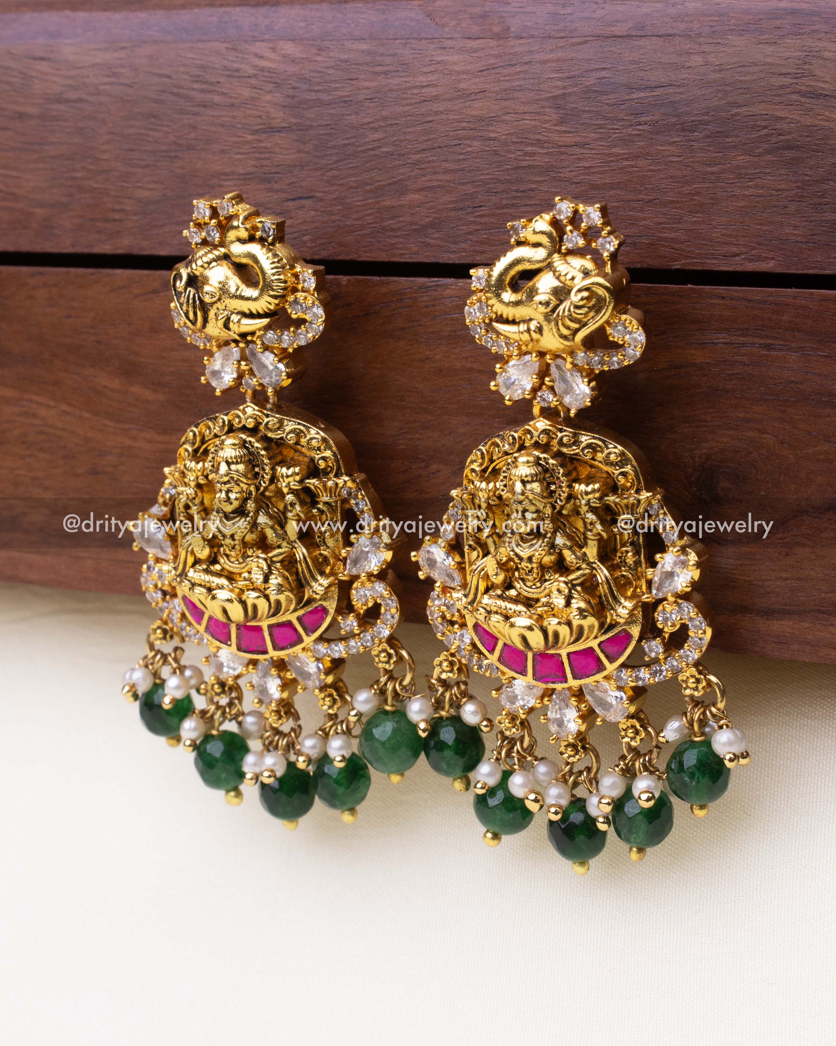 Front view of premium temple dangler earrings featuring goddess carving, elephant stud, and kemp stone detailing.