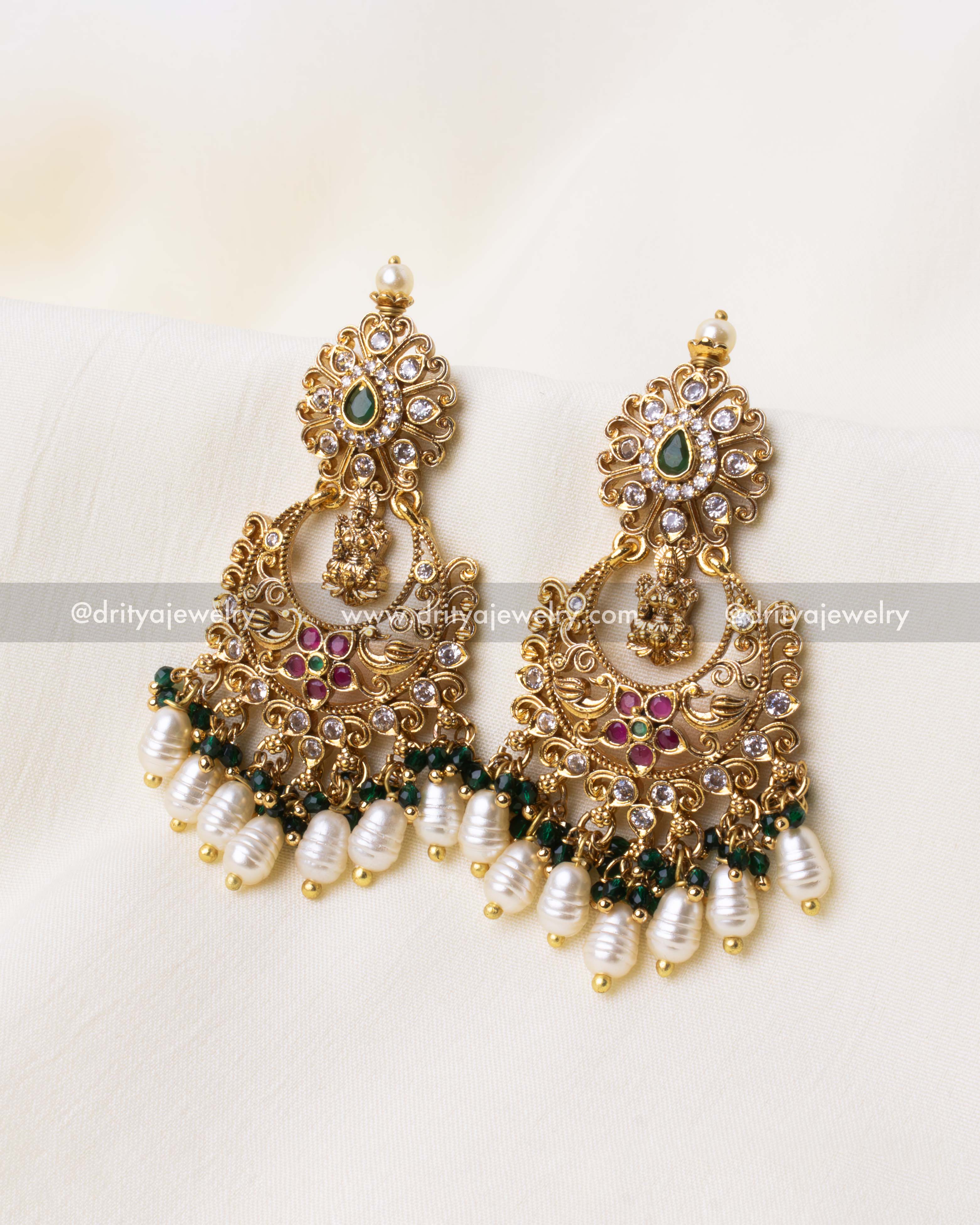 Opulent green Chandbali earrings featuring intricate nakshi design, AD stones, and pearl embellishments.
