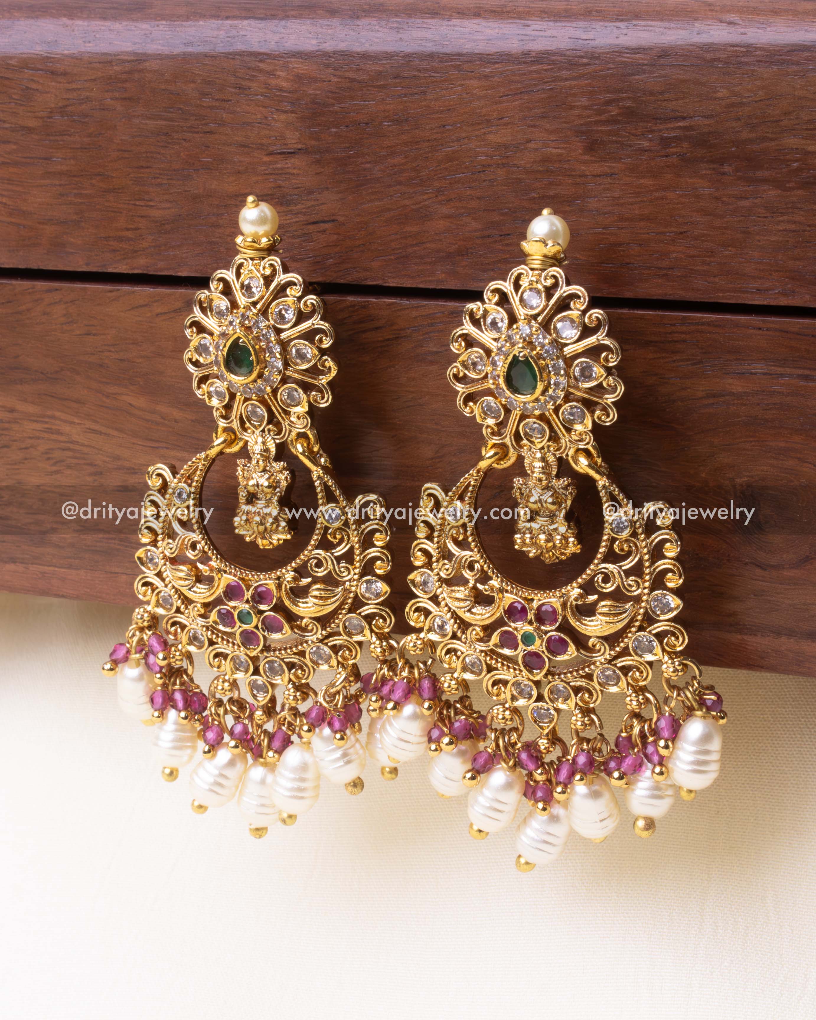 Elegant pink Chandbali earrings featuring nakshi craftsmanship, pink gemstones, and pearl embellishments.