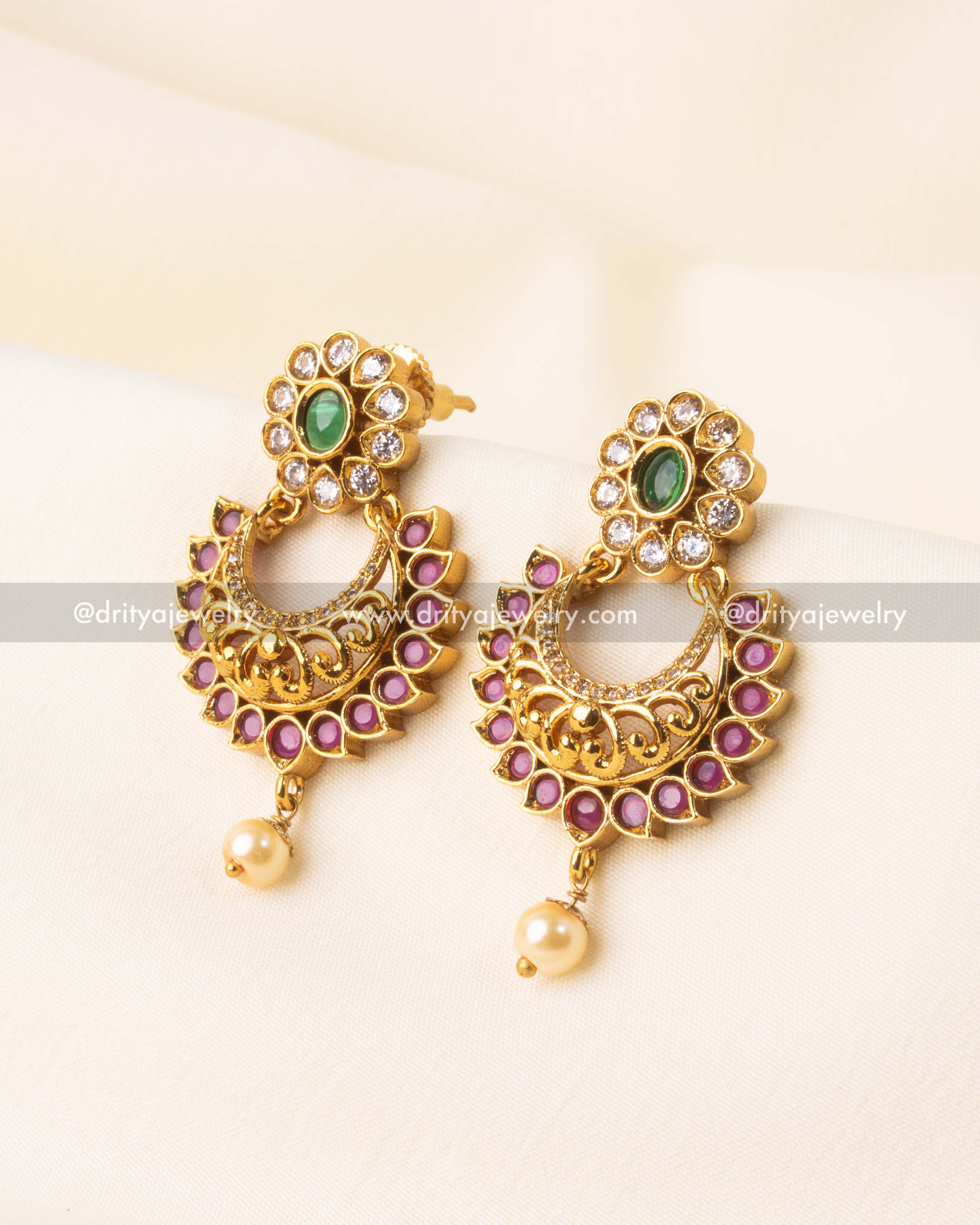Traditional Chandbali earrings with ruby accents, gold-plated finish, and a pearl drop.