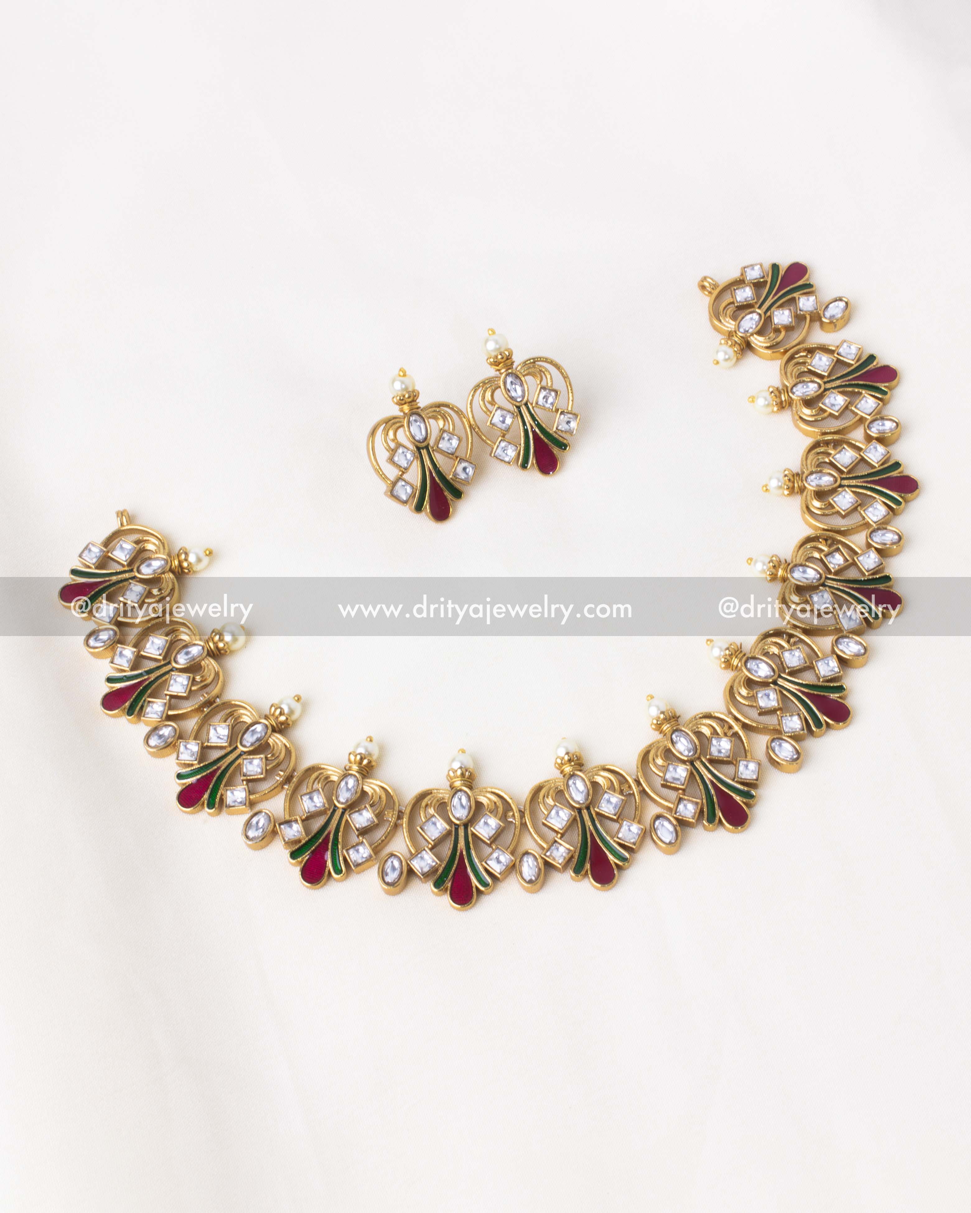 Elegant gold-plated necklace set with peacock motifs, Kundan stones, and red and green enamel accents.