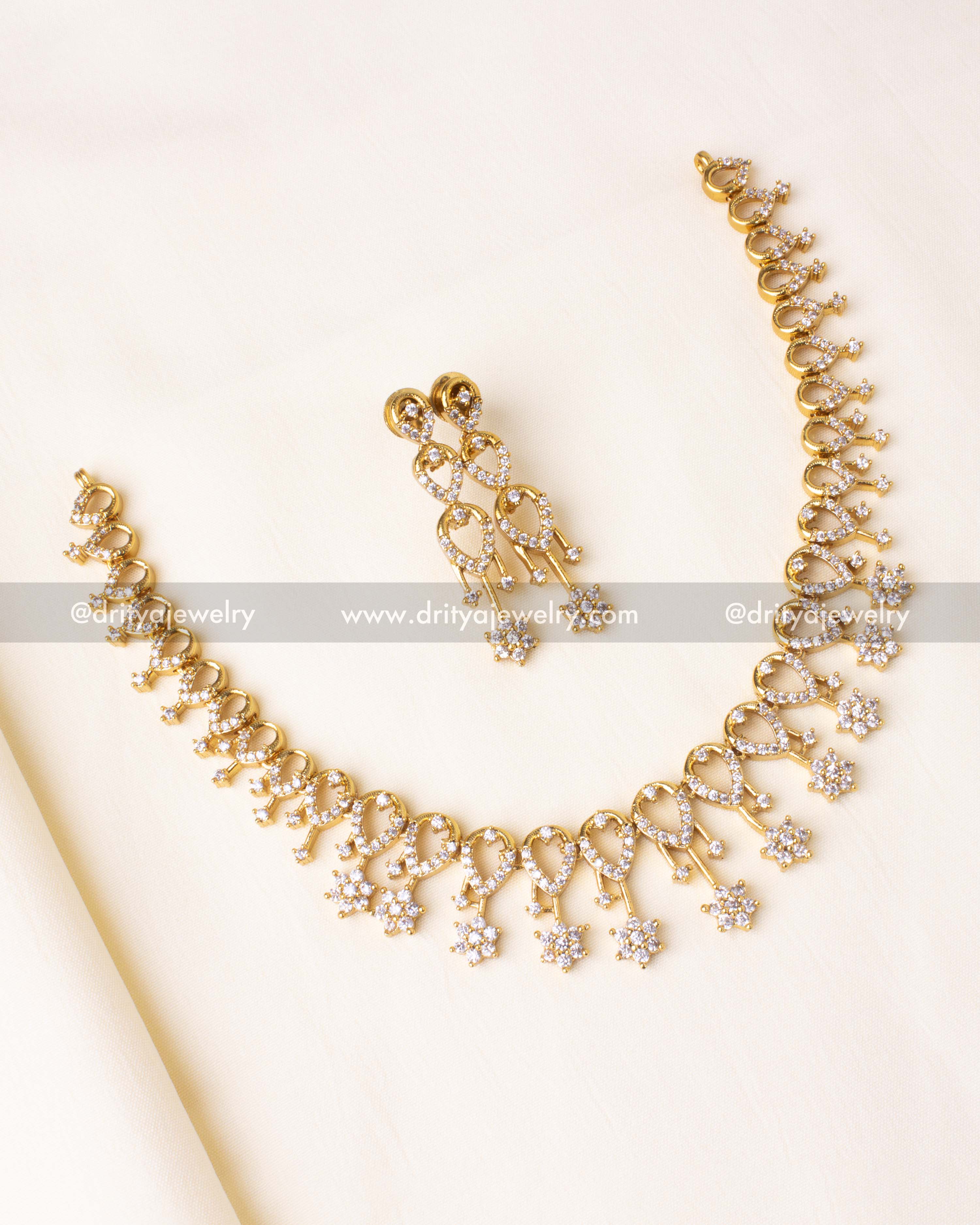 Exquisite gold-plated necklace set with shimmering CZ stones and delicate floral motifs.