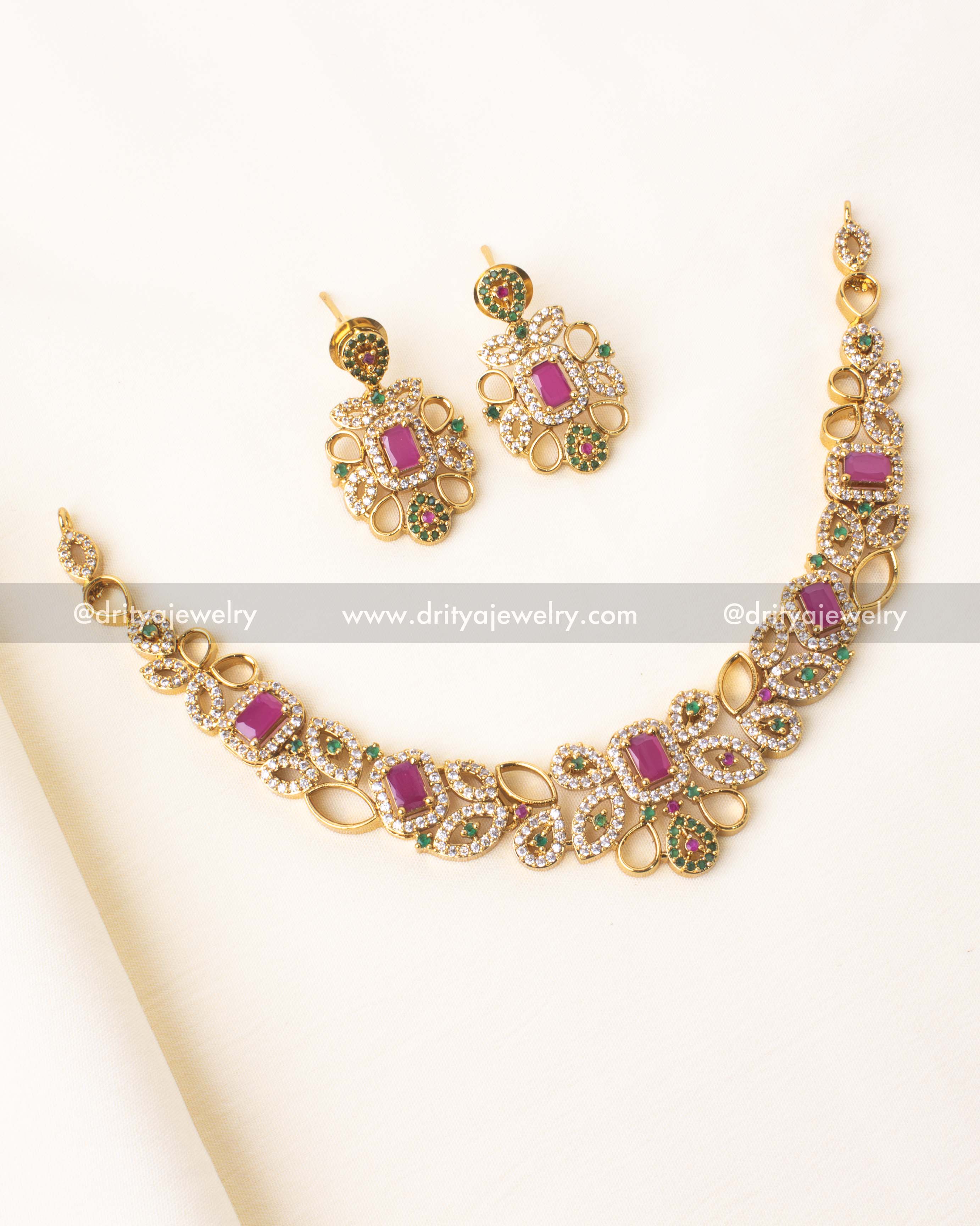 Elegant short necklace with pink and green stones, gold-plated finish, and matching earrings.
