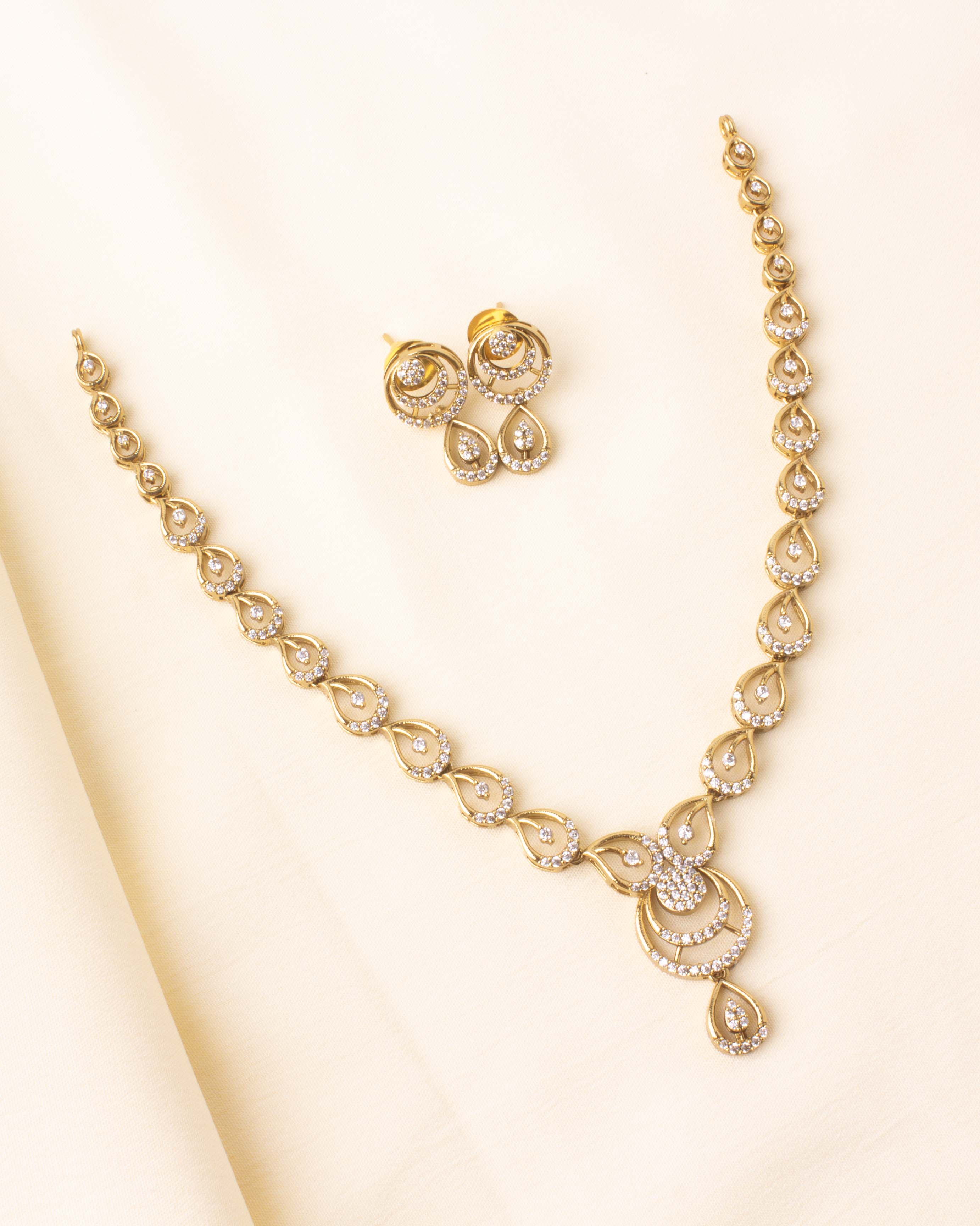 Short necklace with gold finish and CZ-studded tear-drop designs.