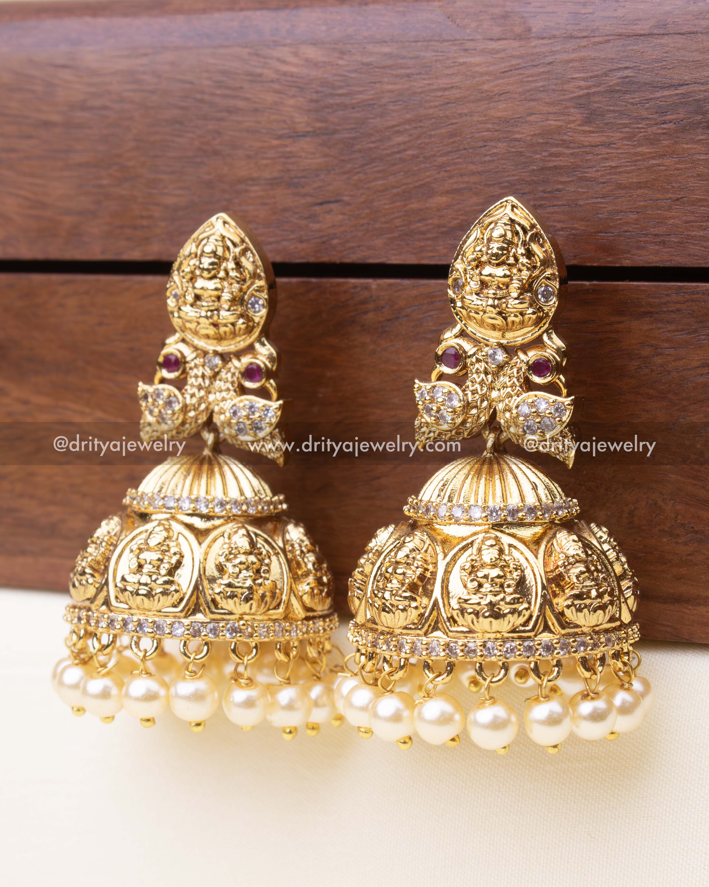 Premium gold replica Lakshmi jhumka earrings with pearl drops and ruby detailing.