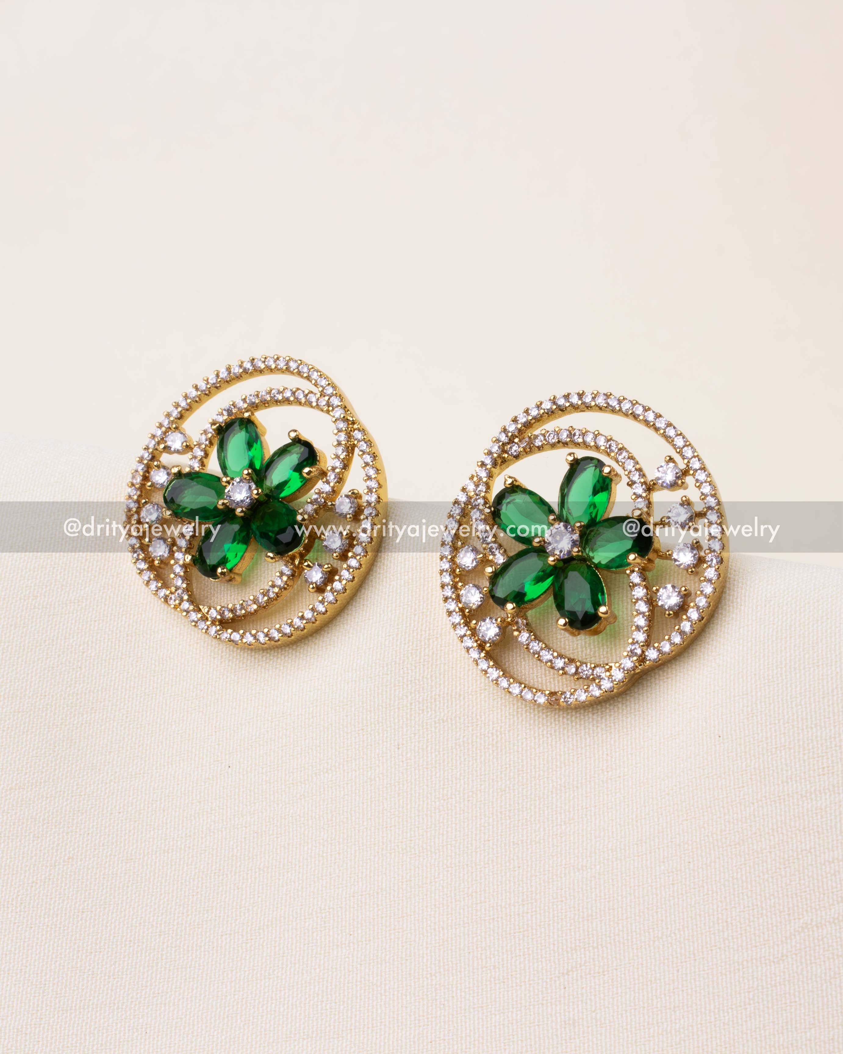 Premium stud earrings with green floral centerpiece and CZ spirals in gold finish.