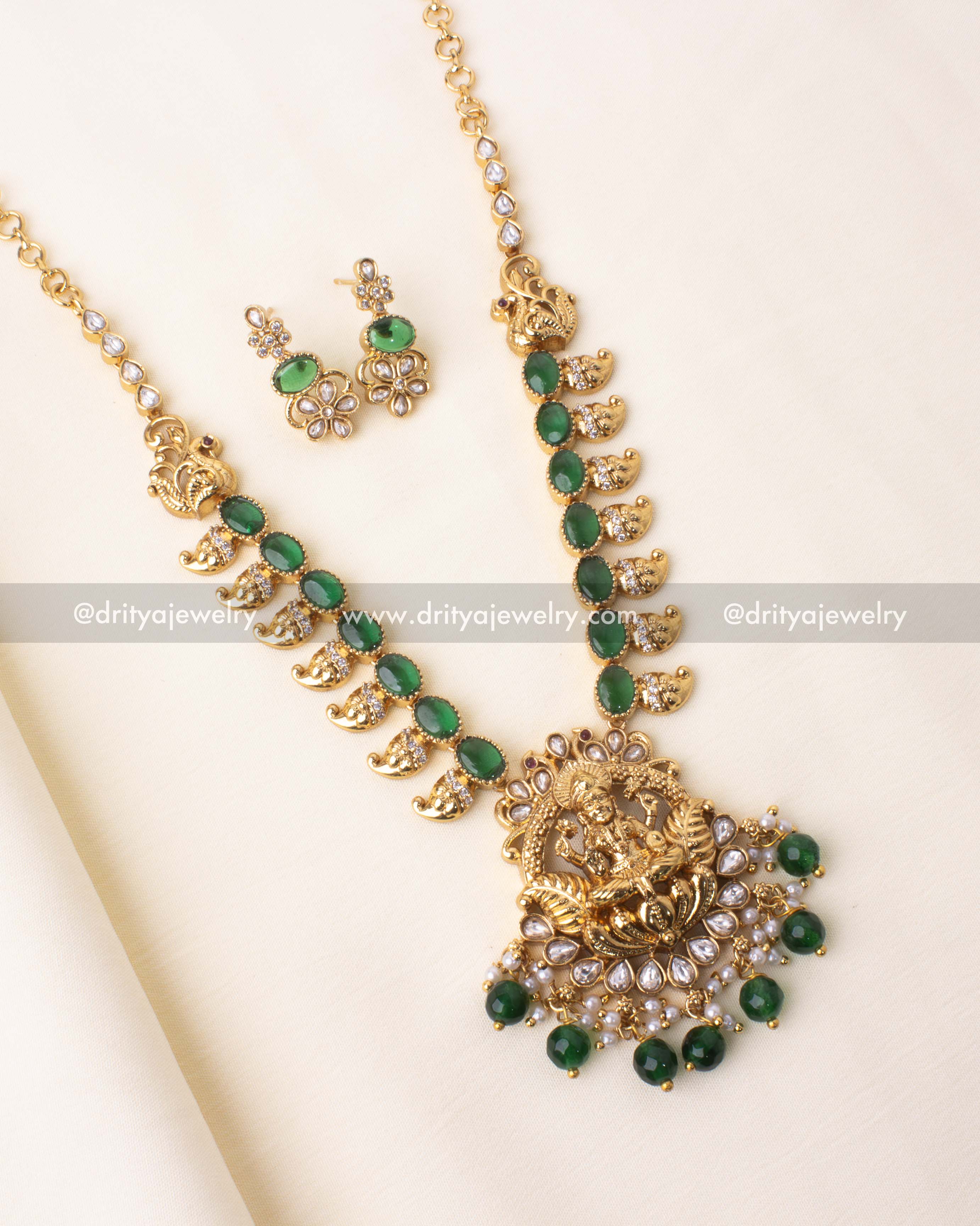 Traditional Nakshi necklace with green stones, pearls, and a Lakshmi pendant.
