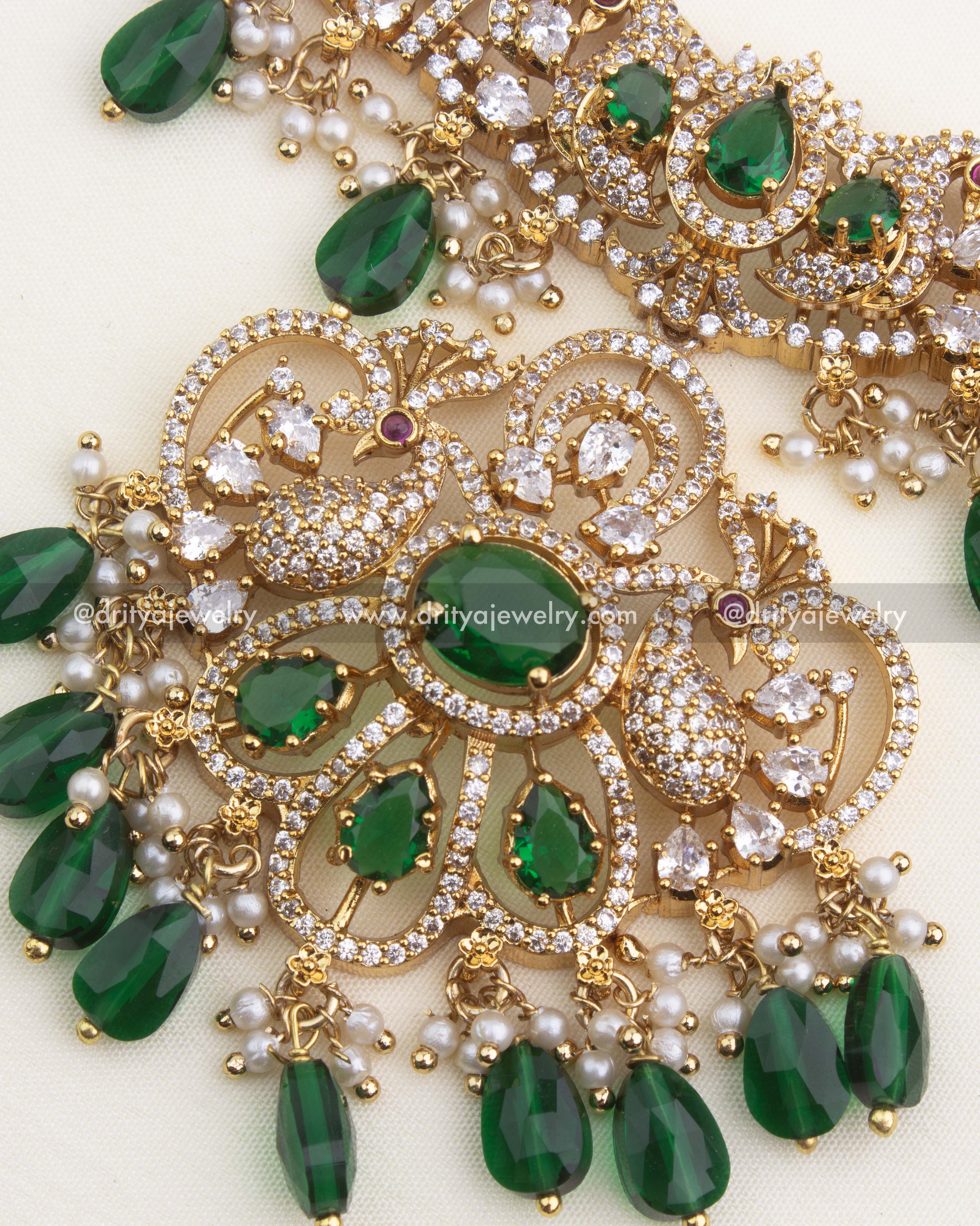 Close-up of premium jalebi-style necklace featuring layered CZ stone lines, green droplets, and pearl detailing.