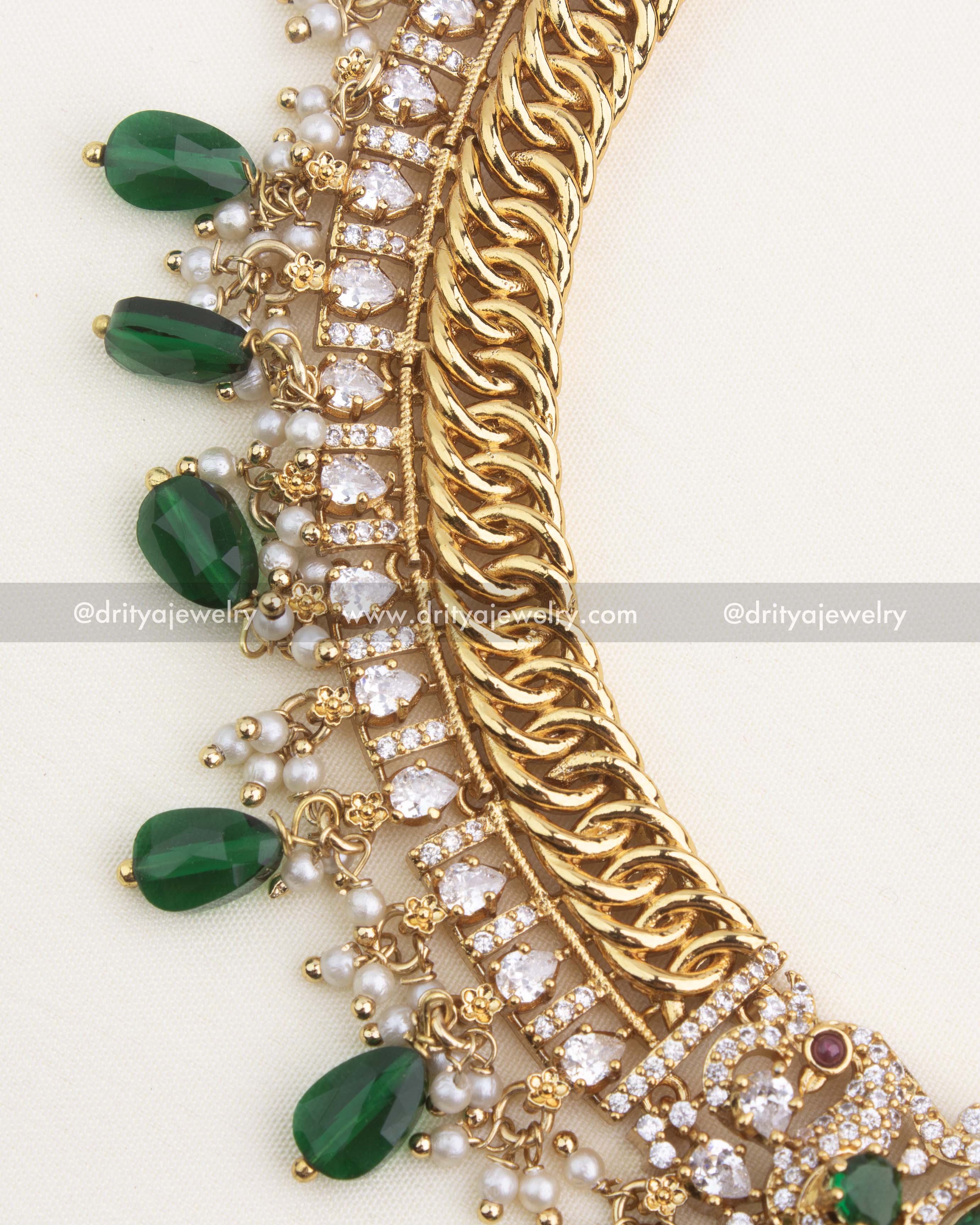 Close-up of premium jalebi-style necklace featuring layered CZ stone lines, green droplets, and pearl detailing.