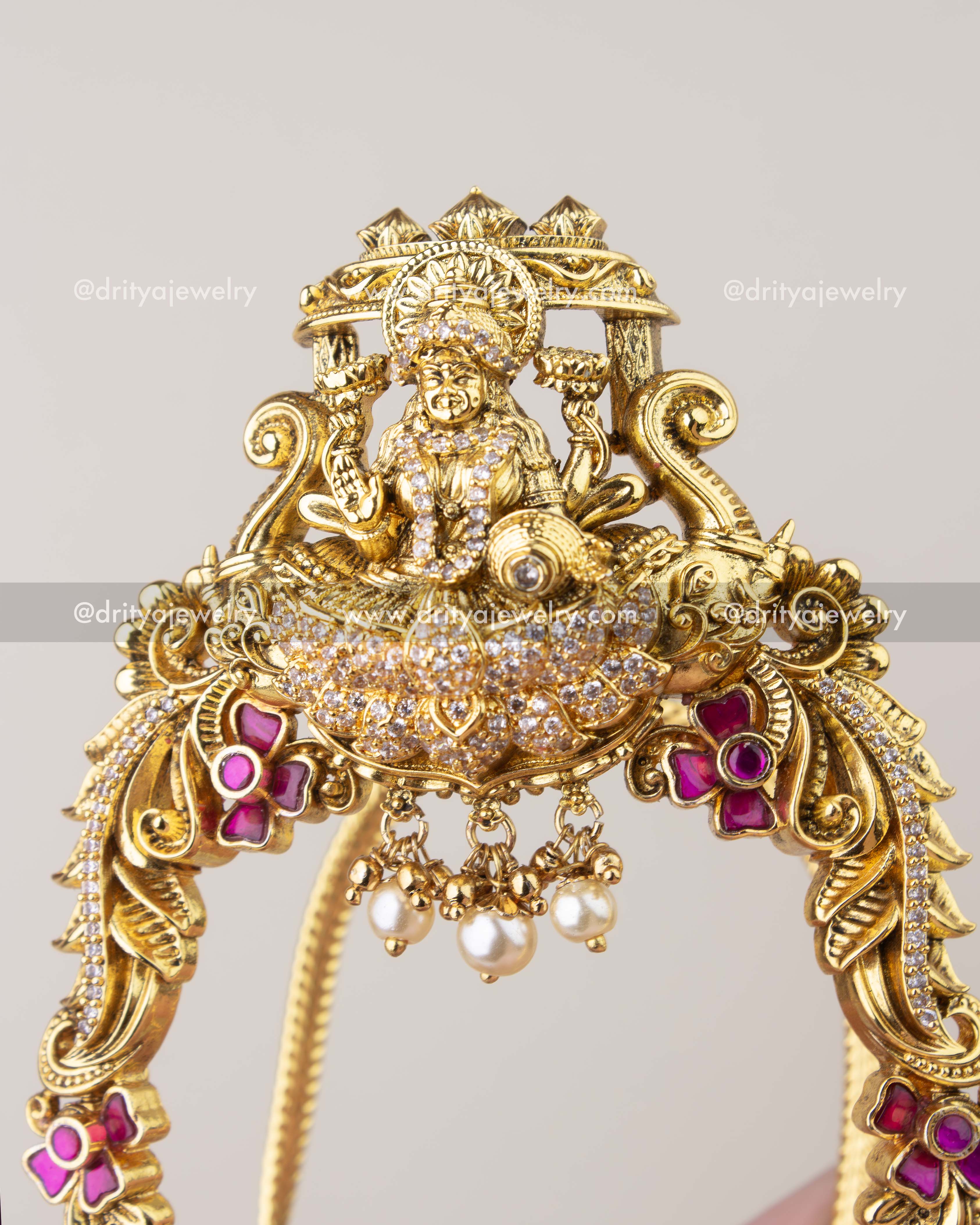 Close-up of Kemp temple vanki showing Lakshmi carving, crystal work, and pearl drops