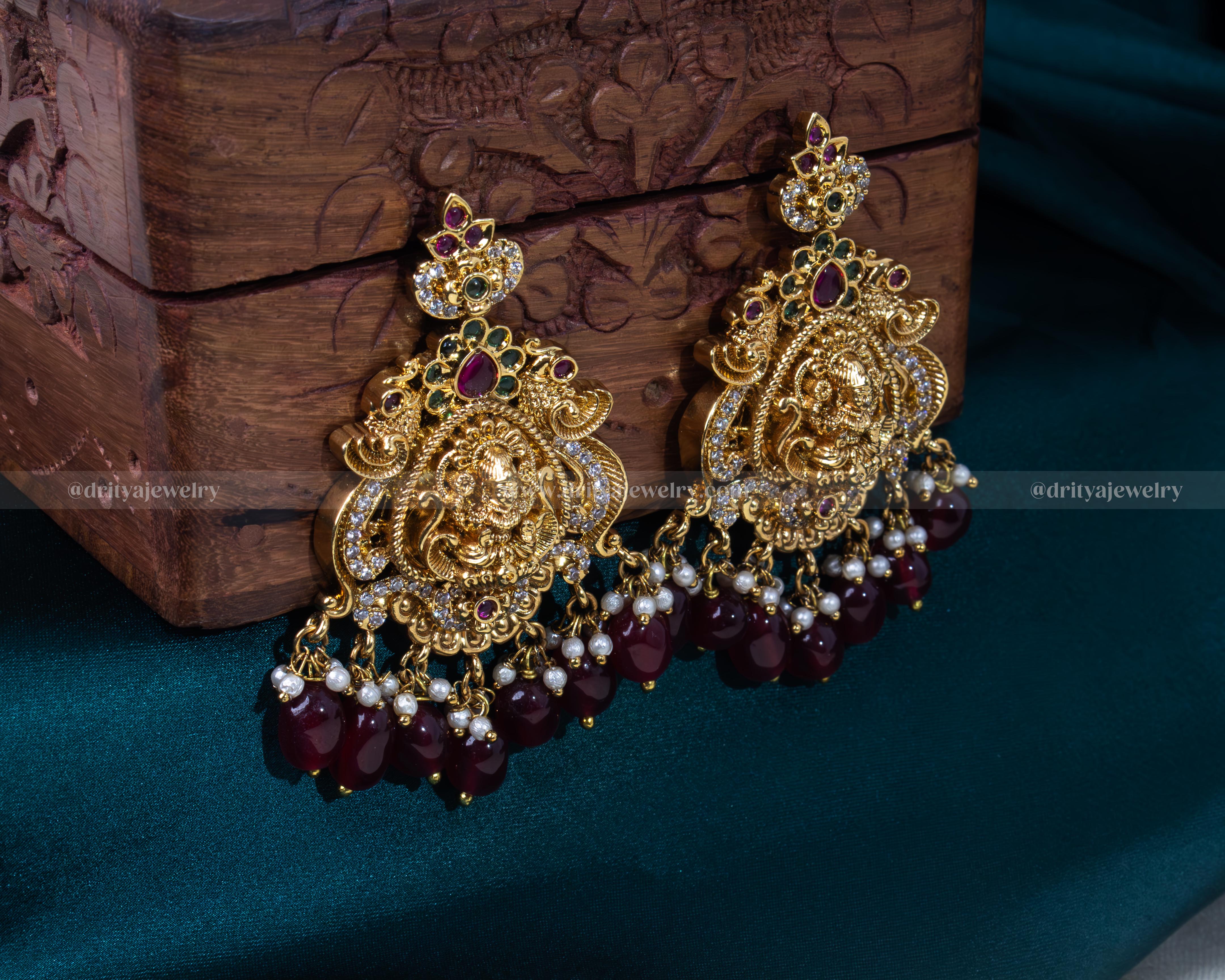 Earrings of Lakshmi Devi motif long haram bridal necklace set adorned with gemstones and pearls by Dritya Jewelry.